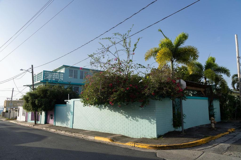 This urban three-story home is ideally located in a vibrant central area of Isabel II, just steps from Playa de los Muertos (also known as Sea Glass Beach), the ferry terminal, local markets, shops, and restaurants. With all the amenities of Caribbean town living at your doorstep, everything you need is within easy reach. Whether you're heading out for a morning coffee, catching the ferry, or enjoying a sunset stroll along the shore, this location supports a lifestyle of ease and accessibility.

Upon entering the property, you’re greeted by a fabulous outdoor courtyard and garden reminiscent of Spanish cloisters. The elegantly centered pool, lined with iridescent blue tiles and flanked by two sculptural lion fountains that give the home its name, fills the space with the soothing sound of flowing water. Throughout the property, touches of traditional Spanish and colorful Creole design can be appreciated, including classic Puerto Rican breeze blocks and decorative rejas.

The house is thoughtfully arranged into three distinct living quarters, with staircases and multiple access points that allow the property to be easily separated into three independent rentable units—making it ideal for multi-generational living, long-term rentals, or short-term income opportunities.

The main level is perfect for entertaining and receiving guests. The common gathering areas include an outdoor wet bar and poolside dining shaded under bougainvillea—ideal for evening card games or relaxed lounging with friends and family. This spectacular outdoor space connects seamlessly to a spacious living room and an oversized, fully equipped kitchen with bar seating and ample dining space. At the rear, you’ll find a full bath and a quiet, air-conditioned guest bedroom with its own cozy and private outdoor green patio.

The upper-level principal suite is the perfect retreat from the vibrant town atmosphere, offering a quiet and intimate environment with views of the north-side ocean. This large open space includes an ensuite bathroom and kitchenette, providing complete privacy. Fully air-conditioned, it also features its own living area for lounging and a dining or remote workspace. The outdoor balcony is ideal for hanging a hammock, reading a book, or enjoying a siesta surrounded by ocean views and lush greenery.

The second level offers generous accommodations for family and guests, with two air-conditioned bedrooms, a shared full bathroom with laundry, and a comfortable living space. The bedroom to the left features its own outdoor sitting area, while the bedroom on the right includes a dedicated workspace.

Outside, the courtyard also includes an outdoor shower and a gated carport with space to park one vehicle while away from Vieques. The outdoor pump room provides additional storage space.

Situated on a 3,312-square-foot lot, with its prime location and beachside charm, this property is equally suited as a full-time residence or an exceptional investment opportunity. Designed for those who value proximity, walkability, and connection to community life, this home offers not just a place to live—but a dynamic lifestyle experience right outside your door.