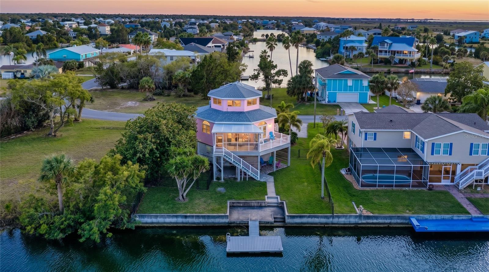 ICONIC PINK three-story octagon WATERFRONT home with PRESERVE & GULF VIEWS – ACTIVE VACATION RENTAL – SOLD TURNKEY in Hernando Beach!
Welcome to one of the most unique and eye-catching homes on the coast—this 3-story octagon WATERFRONT retreat perfectly positioned to capture BREATHTAKING PRESERVE AND GULF VIEWS. Located in the heart of Hernando Beach, this TURNKEY property blends architectural character, modern updates, and the ultimate FLORIDA COASTAL lifestyle.
The second-story MAIN LIVING LEVEL features an OPEN-CONCEPT floor plan filled with natural light, SHIPLAP accent walls, and seamless INDOOR-OUTDOOR living. The DESIGNER KITCHEN showcases GRAY SHAKER CABINETRY, QUARTZ COUNTERTOPS, TILE BACKSPLASH, FLOATING SHELVES, FARMHOUSE SINK, GLASS-TOP COOKTOP, BUILT-IN OVEN, AND HOOD VENT. This level also offers a spacious guest bedroom, full bath with GLASS-ENCLOSED tub/shower combo, and a convenient laundry area tucked behind a stylish BARN DOOR. Step outside to enjoy COASTAL BREEZES from both the BALCONY AND SCREENED PORCH overlooking the peaceful PRESERVE.
A striking SPIRAL STAIRCASE leads to the third-level PRIMARY SUITE, where you’ll find the most spectacular PANORAMIC VIEWS in the home. Take in SWEEPING SUNSETS, GULF WATERS, AND UNTOUCHED NATURAL LANDSCAPES from your private retreat. The suite features a WALK-IN CLOSET with custom shelving and a beautifully updated ENSUITE BATHROOM with CUSTOM VANITY AND WALK-IN SHOWER WITH GLASS ENCLOSURE AND NICHE.
The outdoor space is designed for true COASTAL LIVING with 75 FEET OF WATERFRONT, a CONCRETE PATIO, and a FLOATING DOCK. Launch your KAYAK OR PADDLEBOARD directly from your backyard and explore serene MANGROVE-LINED WATERWAYS. The FULLY FENCED YARD with two separate sections provides flexibility for PETS, ENTERTAINING, OR FUTURE POOL ADDITION.
Additional highlights include a 2021 ROOF, contributing to approximately $2,501/YEAR HOMEOWNERS INSURANCE, and approximately $4,370/YEAR FLOOD INSURANCE.
Located just a short distance to the HERNANDO BEACH BOAT LIFT, offering EASY ACCESS TO THE GULF for boating enthusiasts.
Currently operating as an ACTIVE SHORT-TERM VACATION RENTAL and being SOLD FULLY FURNISHED / TURNKEY, this property is ideal as a PRIMARY RESIDENCE, SECOND HOME, OR INCOME-PRODUCING INVESTMENT.

Located in the vibrant HERNANDO BEACH WATERFRONT COMMUNITY, residents enjoy BOATING, KAYAKING, PADDLEBOARDING, FISHING, AND DIRECT ACCESS TO THE GULF. Just minutes from Weeki Wachee Springs State Park, plus nearby SHOPPING, DINING, AND MEDICAL FACILITIES. The area is GOLF CART FRIENDLY, allows SHORT-TERM RENTALS, and has NO HOA AND NO DEED RESTRICTIONS, making it ideal for FULL-TIME LIVING, A VACATION HOME, OR A HIGH-PERFORMING INVESTMENT PROPERTY. With convenient access to the Suncoast Parkway, commuting to Tampa, Brooksville, and surrounding areas is easy. RARE, ICONIC, AND UNLIKE ANYTHING ELSE ON THE MARKET -- YOUR WATERFRONT PARADISE AWAITS.