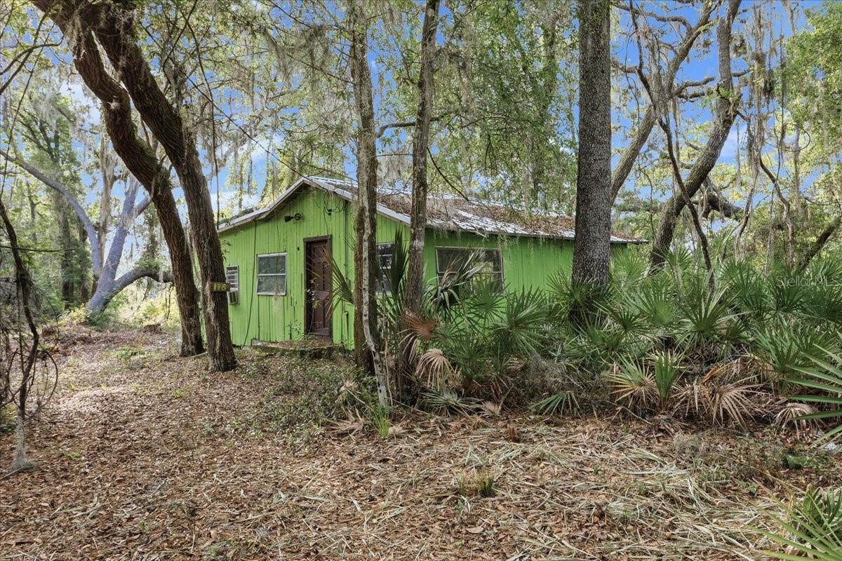 Virtually Staged. Escape to your own private slice of Old Florida. Nestled between two peaceful private lakes, this unique property offers 4+ usable acres surrounded by towering oaks, native palms, and abundant wildlife, creating the perfect setting for a fishing retreat, hunting camp, weekend getaway, or future homesite.

The property includes an approximately 800-square-foot, 2-bedroom, 1-bath cabin ready for your vision and renovation. ***NOTE: SOME INTERIOR HOUSE PHOTOS HAVE BEEN VIRTUALLY STAGED***Metal roof approximately 15 years old. Electric service is connected, and a well and septic system are already on site, although buyers should verify their condition and functionality.

Whether you're casting a line at sunrise on private lake, exploring your own wooded acreage, or enjoying the quiet beauty of nature, this property offers the privacy and seclusion that's becoming increasingly difficult to find. With room to roam, waterfront on two private lakes, and endless outdoor opportunities, this is a rare chance to own a truly one-of-a-kind retreat.

Call agent to schedule a showing.