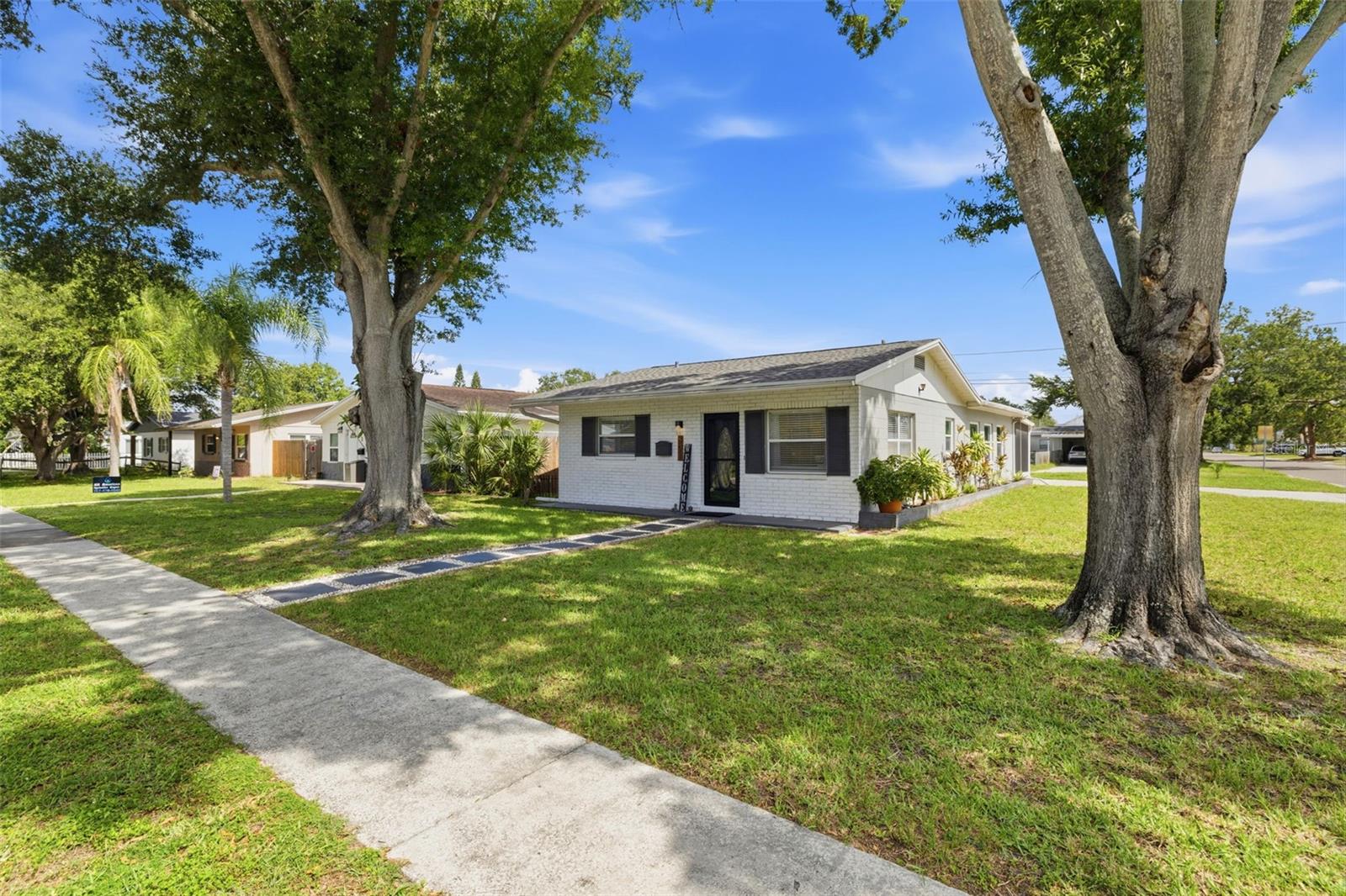 Welcome Home! This light and bright, beautifully updated 2-bedroom, 2-bath block home sits on a spacious corner lot and offers an impressive 1,431 square feet of living space, making it one of the largest and most versatile homes in its category. Filled with natural light and timeless charm, you’ll feel right at home the moment you walk through the front door. One of the standout features of this home is the oversized bonus/flex room located at the rear of the property. Perfect as a family room, home office, playroom, media room, or a combination of all three, this versatile space could also easily serve as a third bedroom, with a separate entry already in place. The beautifully updated kitchen is the heart of the home, featuring white shaker cabinetry, quartz countertops, stainless steel appliances, a classic subway tile backsplash, and a sleek dedicated coffee bar, creating the perfect space to start your mornings or entertain guests. The spacious primary suite offers a private retreat with an updated ensuite bathroom and walk-in shower. Thoughtfully updated throughout, the home features newer flooring, fresh interior paint, new interior doors, newer windows, a hurricane-rated sliding glass door, a newly installed roof with hurricane clips for added peace of mind, a gas water heater, and an interior laundry room. A new storm door with a retractable screen provides additional functionality while allowing fresh air and natural light to flow through the home. Step outside to the covered and screened lanai, a true Florida living space perfect for relaxing or entertaining year-round. The generous corner lot offers plenty of room to create your dream backyard. A oversized driveway and storage shed provide ample parking and storage options. Conveniently located between Downtown St. Petersburg, Tampa, and the Gulf Beaches, this home offers easy access to I-275, the Gandy and Selmon Expressways, Tampa International Airport, St. Pete-Clearwater International Airport, shopping, dining, parks, schools, and universities. Just moments from the thriving 4th Street corridor, you’ll enjoy all the conveniences of one of St. Petersburg’s fastest-growing areas. Whether you’re searching for a primary residence, seasonal getaway, or investment opportunity, this move-in ready home offers exceptional value, flexible living space, and an unbeatable location. Bonus: The seller’s preferred lender is offering 1.25% toward the buyer’s closing costs or a rate buydown, creating an excellent opportunity for qualified buyers.