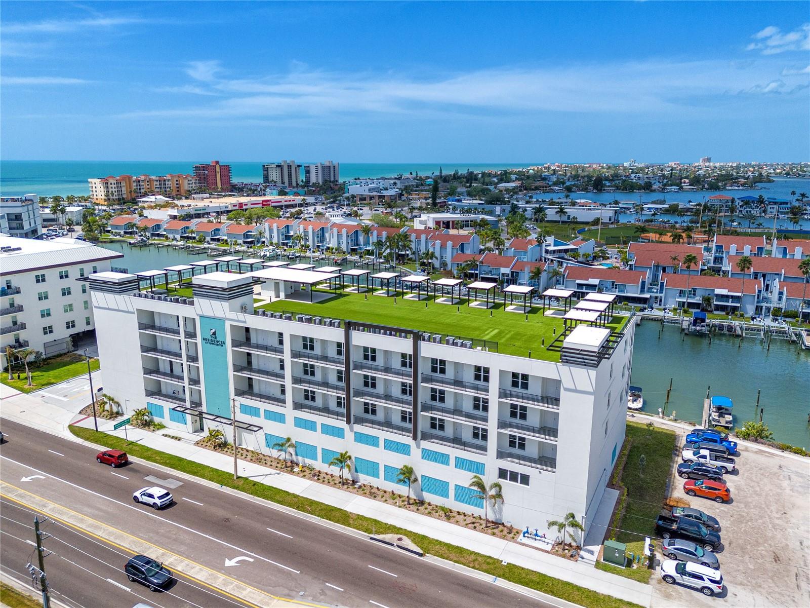 ONE OR MORE PHOTOS ARE VIRTUALLY STAGED  Welcome to the crown jewel of Madeira Beach living. This stunning penthouse residence in a boutique, luxury building delivers an elevated coastal lifestyle with resort-style amenities and breathtaking panoramic views.

Unit 501 is an unfurnished 3-bedroom, 3-bathroom penthouse with a versatile bonus room, designed with an elegant open-concept layout, soaring ceilings, and expansive glass sliders that flood the home with natural light. The spacious living room and primary suite open to a large private balcony showcasing sweeping views of the Gulf, beach, pool, canals, and Intracoastal — the perfect setting for unforgettable sunsets.

The chef’s kitchen is a true centerpiece, featuring stainless steel Café appliances, abundant cabinetry, and a large island with bar seating, sink, and dishwasher, seamlessly flowing into the dining and living areas for effortless entertaining. The primary suite offers a walk-in closet, additional hall closet, and a spa-inspired bathroom with dual sinks, built-in seating, powder drawer, and a walk-in shower. Each guest bedroom includes generous closet space and an ensuite bath — one with a walk-in shower and the other with a shower/tub combination that also provides convenient hallway access.

The flexible bonus room is ideal for a home office, nursery, or library. An oversized laundry room includes a washer and dryer, sink, countertop workspace, cabinetry, and shelving, while additional storage closets are thoughtfully positioned throughout the home.

Residents enjoy gated security with key/fob access, two assigned covered garage parking spaces, guest parking, golf cart spaces, and ground-level storage for bikes, kayaks, and paddleboards. Relax by the heated pool and hot tub overlooking the canal, or head to the rooftop deck to take in 360-degree views stretching from Madeira Beach and Redington Beach to Treasure Island and downtown St. Petersburg. Unit 501 also features a private rooftop pergola exclusive to the residence, complete with power for a fan and beverage fridge — a rare and exceptional outdoor retreat.

This is luxury coastal penthouse living at its finest, combining modern design, premium amenities, and an unbeatable Madeira Beach location.