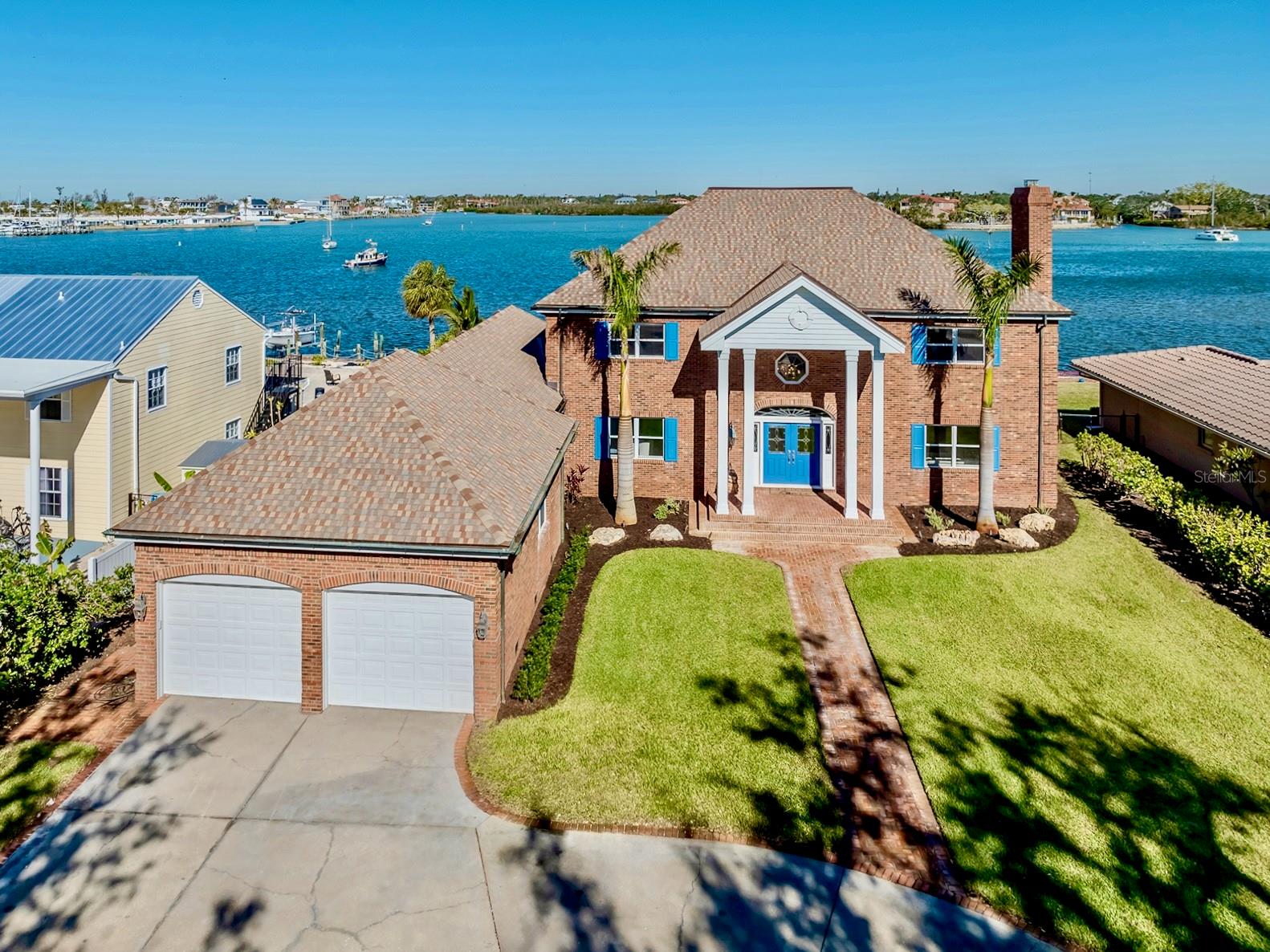 Rare opportunity on Venice Island! Luxury 5,058 SF Waterfront Brick Colonial Home with AMAZING WATER VIEWS and no bridges to the Gulf of Mexico situated on almost ½ acre! This home is a BOATER’S DREAM. Discover timeless style and modern luxury in this magnificent 5 bedroom, 4.5 bathroom home, situated on Roberts Bay. This home has all the right spaces with premium finishes throughout. Embracing classic architecture with ornamental shutters, brick quoins, a welcoming front porch, and a grandiose circular driveway leading to an oversized 4 car garage, this home presents an unrivaled lifestyle. Step through the impressive entrance into the foyer, where a curved staircase and a stunning chandelier create a striking first impression. The formal dining and living rooms at the front of the home emanate sophistication, with the living room showcasing decorous ornamental trim and a wood-burning fireplace. The main gathering place is the substantial family room, featuring a wet bar, sliding doors to the outdoor area, and large windows providing the space with natural light and offering incredible water views. Adjoining the family room, the kitchen is a chef's dream, complete with a large island with bar seating, quartz countertops, Subzero Refrigerator and Freezer, electric stovetop, double oven, a coffee bar, and a walk-in pantry with an additional refrigerator. The dinette area and kitchen overlook the pool and serene bay views. The downstairs bedroom, accompanied by an ensuite bath and private access to the pool area, provides an ideal retreat for guests. A sizable laundry room provides functionality with ample cabinetry, a utility sink, a laundry chute (from primary closet), and countertop workspace. Upstairs, the extravagant primary suite is a sanctuary of comfort and style. It features two walk-in closets, a cozy sitting room with a window seat, and access to a private balcony with an integrated swinging daybed and spectacular water views. The primary bathroom enjoys a soaking tub, a walk-in shower with a bench, and dual sinks. The split room design allows for plenty of privacy with an additional three upstairs bedrooms on separate side of home which are thoughtfully designed, including one with an ensuite bath and water views. Venture outside to the paradigm of luxury living. The covered porch and pergola seamlessly flow to the superb saltwater pool and spa, surrounded by travertine decking. With a sun shelf, stunning blue tile, and year-round heating, this pool area is perfect for entertaining or relaxing. The backyard offers breathtaking panoramic water views and plans for future additions, such as a boat lift. Additional home highlights include copper downspouts, 6-panel interior doors, an outdoor shower, a side walkway, 3 HVAC systems, irrigation from a private well, second-floor balcony staircase, and a 14,000 lb boat lift. Home is located approximately 0.4 miles from Venice Beach and about 0.7 miles from Historic Downtown Venice. Home is in close proximity to shops, restaurants, Venice Theatre, Venice Community Center, Venice Public Library, Venice Hospital, Golf Courses, parks, Legacy Trail, Venice Art Center, Venice Performing Arts Center, and many other appealing destinations. This home is the ultimate package...LUXURY WATERFRONT LIVING AND THE FLORIDA LIFESTYLE YOU DESERVE! Experience the best of coastal living as your slice of paradise awaits!