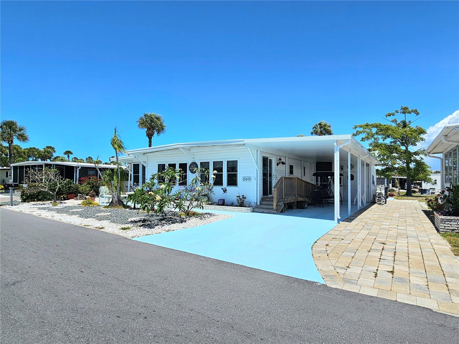 One or more photo(s) has been virtually staged. If you have been looking for an active Florida lifestyle without breaking the bank then you just found it! Venice Isles is one of the most sought-after mobile home communities in Venice, Florida, known for its LOW MONTHLY FEES, resident-owned CO-OP STRUCTURE, and vibrant active lifestyle. This spacious double wide home is steps away from one of the community pools and offers solid construction, major system updates, and endless potential in a prime location near Venice Beach and the Island of Venice. This home has great bones and important improvements already completed, including a ROOF IN 2024, CARPORT 2024 WITH PAN ROOFING, HVAC REPLACED IN 2021, UPDATED WINDOWS IN 2018 and 2013, and a NEW ELECTRIC PEDESTAL INSTALLED IN 2024. Inside, the light and bright kitchen features GRANITE COUNTERS, STAINLESS APPLIANCES, a closet pantry, and an inviting layout ideal for everyday living or seasonal enjoyment. Accessibility has been thoughtfully incorporated with WHEELCHAIR ACCESS from the carport into the home, ACCESSIBLE VANITIES, and easy-flow living spaces. The Florida room is surrounded by windows, creating a sunny bonus space perfect for relaxing, hobbies, or entertaining guests. The primary suite includes an ENSUITE BATHROOM with a WALK-IN SHOWER, GLASS SHOWER DOORS, ACCESSIBLE VANITY, and walk-in closet. A private secondary entrance from the closet area leads directly to a peaceful patio space. The guest bathroom offers a tub with shower, glass doors, linen closet, and another ACCESSIBLE VANITY. Outside, enjoy beautiful landscaping, classic CLAMSHELL SHUTTERS, a LARGE COVERED CARPORT, PAINTED DRIVEWAY, and multiple storage options including a shed with electric, EXTERIOR WASHER DRYER AREA, and additional storage space between the home and shed for tools, beach chairs, or seasonal items. Venice Isles is a highly active 55+ community featuring TWO COMMUNITY POOLS, a LARGE TIKI HUT at the main pool, tennis courts, PUTT-PUTT GOLF, HORSESHOES, SHUFFLEBOARD, and a full calendar of social events and activities. Located just minutes from Venice Beach, the Island of Venice, shopping, dining, golf, fishing, and top-rated medical facilities. You are also within easy reach of Siesta Key Beach and Sarasota’s arts, culture, and entertainment. If you are searching for an affordable home in Venice, FL with LOW FEES, strong community amenities, and room to make it your own, this is an opportunity worth seeing.
