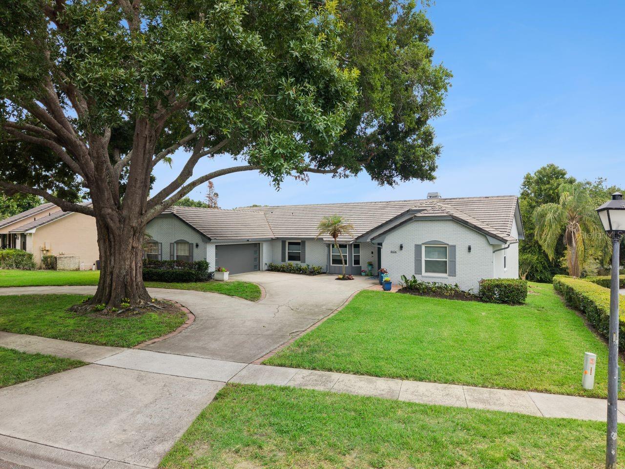 Delightfully charming and remodeled in a Modern style, in desirable South Bay! Located in the heart of Dr.Phillips/SW Orlando, and sitting on a conveniently quiet street, this lovely home sits on .69 acre, pond-front lot, with a gentle slop and large yard. Created in sync with today's 'open' contemporary feel, you'll love the bright, flowing Great room, Dining, Parlor & Kitchen the moment you enter.. Painted, designed and finished primarily in alabaster, grey and charcoal tones, plus take note of some of the details: luxury vinyl & large porcelain tile flooring, brick accents, dual skylights, custom Modern fixtures, newer windows & sliders, & vaulted ceilings. The Kitchen renovation is stunning and purposeful, which includes an enormous granite center island with storage drawers, soapstone countertops, glass tile back-splash, custom-lighted cabinetry with display windows, stainless appliances and more. The core of the home is ideal for entertaining as well! The Primary suite is cozy and complete - custom accent wall, luxury vinyl flooring, large soaking tub, custom walk-in 'rain-head' shower, dual vanities, custom mirrors, rectangular modern tile, walk-in closet & block glass natural light.. Split Guest wing of the home features a one-of-a-kind closet-bedroom with a center island with drawers & ironing board, and surrounding built-ins for all kinds of your clothes! Two additional sunny bedrooms plus a renovated full bath. The rear covered Lanai faces South and overlooks a shimmering, Pebble Tech screened pool, Sun-shelf, spa and a most peaceful view of South Bay's only natural pond; brick pavers & travertine flooring too. Additional features include: inside laundry, 2-car side entry garage, tile roof, circular driveway & an incredible massive oak tree, set towards the front of the property. Only seconds out of the neighborhood to all that is Sand Lake Road, A-rated public schools, Dr.Phillips YMCA, attractions, I-4 and the Bay Hill Club & Lodge. This is a wonderful opportunity.