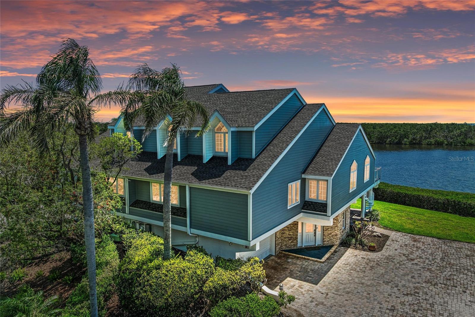 Tidy Island classic waterfront home with magnificent panoramic water views of Sarasota Bay. Even the stargazing is magnificent! Discover the epitome of waterfront living with three bedrooms and two-and-a-half baths in this 3,277-square-foot home. This beautiful home invites you to experience the joy of sun-soaked days and tranquil nights by the Bay, with timeless architecture, spacious interiors, high ceilings, an abundance of natural light, plus a wood-burning fireplace and private elevator. This is your opportunity to call Tidy Island home, where every day feels like a vacation. This classic floor plan is designed for easy living with wood flooring in the kitchen, dining and living room all flowing together and wonderful for entertaining and family gatherings. Enjoy the custom-built kitchen with two ovens, two dishwashers, granite counters, island with sink and breakfast bar, wine refrigerator, tile backsplash, built-in desk and pantry. The large primary bedroom offers a walk-in closet, en-suite bath with a classic claw foot bathtub, quartz counters, dual sinks and plenty of cabinet and shelving space. On the top floor, enjoy a big office/loft with built-in bookcases plus two bedrooms and shared bath. Go out onto the balcony just off the sun/Florida room to relax and experience breathtaking water views of Sarasota Bay to downtown Sarasota. Take the spiral staircase to the ground floor lanai area to enjoy grilling, picnics and family gatherings. Additional great features include large storage room with epoxy flooring, interior atrium, Hunter Douglas remote control blinds, vaulted ceilings, two new air-conditioning units, two-car garage with epoxy floors, crown molding and ceiling fans throughout. The association fee includes cable, internet, water, sewer, garbage, lawn maintenance, pest control, exterior painting and roof (replaced in 2021). Tidy Island residents enjoy access to two pools and spa, fitness center, Har-Tru tennis courts, walking trails, scenic boardwalks, 24-hour security guard gate, social gatherings in the clubhouse with catering kitchen, outdoor deck with bar and gazebo. Enjoy the lush nature trails that invite you to immerse yourself in the beauty of the surrounding preserve. A kayak launch provides easy access to the Sarasota Bay plus a historical museum. Conveniently only minutes from the sugary sands of Anna Maria Island, grocery stores, shopping, restaurants and golf course. Watch the video and click on the tour to virtually walk through the house.