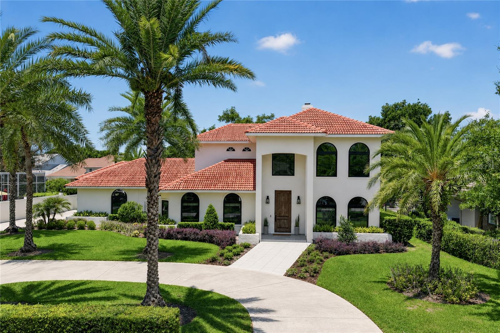 Welcome to an exceptional custom-renovated estate in the heart of Bay Hill, home of the legendary Arnold Palmer Invitational and one of Orlando's most renowned golf communities. Situated on a private oversized lot, this extensively remodeled residence lives like a new custom home with thoughtful luxury upgrades throughout.

Designed for entertaining, the open-concept floor plan features custom wood beam ceilings, designer lighting, and expansive French and accordion doors that fully open to create seamless indoor-outdoor living with stunning pool views. The chef's kitchen showcases custom cabinetry, premium appliances, an oversized island, built-in breakfast nook, and elegant dry bar, while a wine cellar display beneath the staircase adds an elegant touch.

The resort-style backyard is the centerpiece of the home, with the residence wrapping around the pool for maximum privacy and views. Enjoy a fully equipped summer kitchen, outdoor bar, motorized pergola, outdoor shower, and dedicated pool bath. A detached custom-built fitness studio overlooks the pool, creating the ultimate wellness retreat.

The luxurious primary suite features French doors to the pool, custom closet built-ins, and a spa-inspired bath with marble finishes, custom vanities, soaking tub, rain shower, and body jets. A secondary primary suite is located on the first floor, while upstairs offers two bedrooms connected by a Jack-and-Jill bath plus a spacious loft that could easily become a 5th bedroom.

Additional highlights include new windows and doors, LED lighting throughout, a circular driveway, abundant guest parking, and a three-car garage.

Located minutes from Bay Hill Club & Lodge, Restaurant Row, major highways, Universal Orlando, Walt Disney World, Orlando International Airport, and Downtown Orlando, this is a rare opportunity to own a truly one-of-a-kind luxury home in one of Central Florida's most sought-after communities.