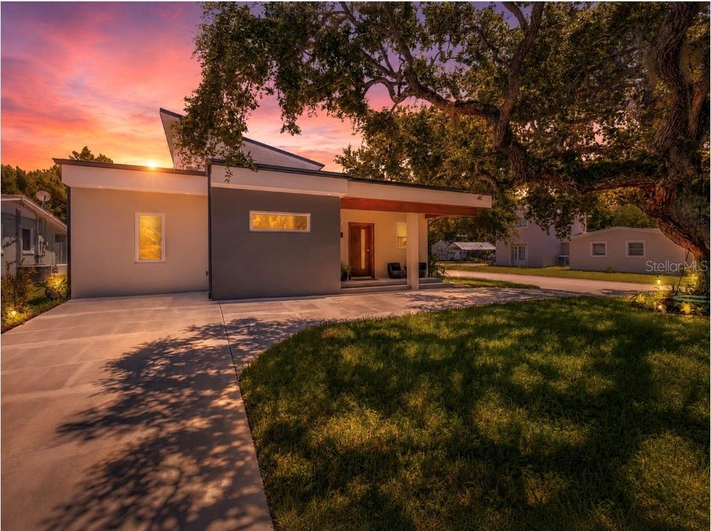 One or more photo(s) has been virtually staged. Meet 3211 Saxon Drive — a bold architectural statement redefining contemporary coastal living in New Smyrna Beach.

This is not your typical beachside home. Blending polished concrete floors, curated design, and a flexible layout, this rare property offers architectural presence, multigenerational flexibility, and an effortless coastal lifestyle just moments from the Atlantic Ocean.

Offering two fully livable spaces on one exceptional property, 3211 Saxon Drive creates opportunities rarely found in today's market. Whether you're seeking room for extended family, a private guest retreat, dedicated workspace, or future income potential, this property adapts beautifully to your lifestyle.

The main residence is a study in clean lines and intentional contemporary design. Polished concrete floors create a sophisticated foundation complemented by natural textures and abundant light. The first level features two guest bedrooms, a full bath, mudroom/laundry area, and a bright flex room currently styled as an office but also suitable as a bedroom.

At the heart of the home, the chef's kitchen and expansive great room create an unforgettable gathering space. Premium Café appliances, an Electrolux double-door refrigerator/freezer, 42-inch custom cabinetry, a hidden walk-in pantry, and a dramatic 12-foot island anchor the space with style and function. Oversized windows flood the interior with natural light while warm wood accents soften the modern aesthetic.

Upstairs, the entire second level is dedicated to a luxurious primary retreat. Enjoy mornings at the coffee bar before stepping onto your private balcony overlooking the oak canopy. The spa-inspired suite features reach-in and walk-in closets, dual vanities, a pass-through shower, and private water closet.

A hidden fifth bedroom adds flexibility as a guest suite, media room, fitness space, creative studio, or secluded office.

Adding even more versatility is the detached guest apartment above the oversized two-car garage. Offering approximately 1,000 square feet, this private space includes a kitchenette, dining area, living room, full bath, bedroom, half bath, and private balcony. Whether used for extended family, guests, workspace, or future rental opportunities, this detached living space is an increasingly rare feature.

Outside, the backyard is ready to become a private resort-style retreat. The seller is currently exploring the addition of a custom pool and will consider offering a credit toward a pool package, allowing buyers the opportunity to personalize the design, finishes, and features. A separate driveway leading to the detached garage and guest quarters enhances privacy, convenience, and parking.

The lifestyle is pure New Smyrna Beach. Walk to the beach at sunrise, explore nearby trails, or launch a kayak or paddleboard into the world-famous Mosquito Lagoon. Enjoy exceptional fishing, boating, wildlife viewing, and unforgettable sunsets while remaining close to local restaurants, boutiques, and attractions.

Architectural, flexible, and nearly impossible to replicate, 3211 Saxon Drive perfectly captures the essence of modern coastal living.