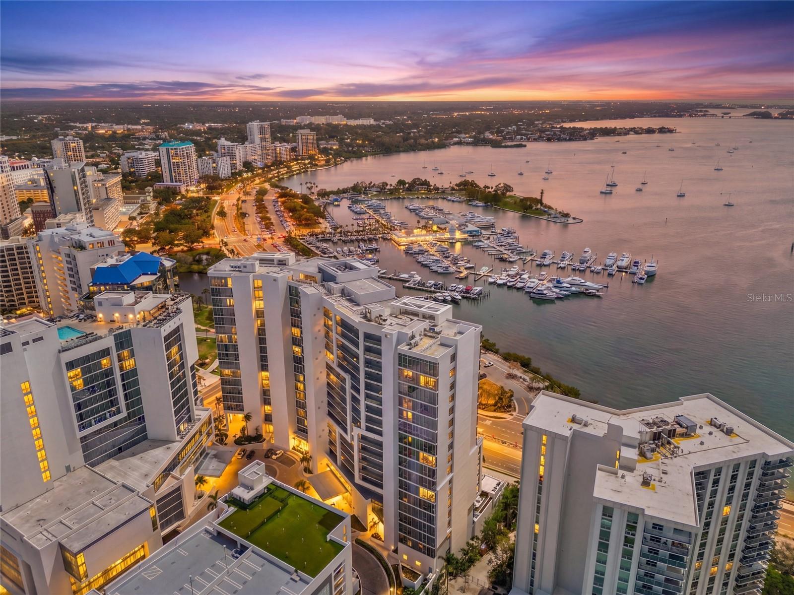 Stunning Sarasota Bay and Marina Jack views, combined with newer construction, make this residence at The VUE a standout opportunity in downtown Sarasota. Ideally positioned, this luxury condominium offers exceptional walkability just steps from premier dining, shopping, and cultural attractions.  Designed to live like a true three-bedroom home, the den has been thoughtfully enclosed with a door and custom Murphy bed—ideal for guests or a private office. A private elevator foyer welcomes you into a bright, open living space where expansive impact-rated sliders frame unobstructed water and city views along with spectacular sunsets. Immaculate interiors showcase porcelain tile throughout the main living areas, while engineered hardwood flooring adds warmth to the primary and second bedrooms. In the primary suite, a custom walk-in closet with built-ins is complemented by an additional reach-in closet, offering excellent storage and organization. The sleek, modern kitchen blends style and function with premium stainless-steel appliances, an induction cooktop, Nolte European cabinetry, and Culligan water treatment at the sink. Everyday convenience is enhanced by a utility room featuring an LG washer/dryer tower and additional storage. Residents enjoy a full suite of amenities including a resort-style pool and spa, state-of-the-art fitness center, rooftop dog park, concierge, valet service, and secure building access. Included with the residence are two garage parking spaces and a private storage unit. Sharing a coveted downtown location alongside the Ritz-Carlton and The Westin—home to its popular rooftop bar—this address offers unmatched access to Sarasota’s vibrant lifestyle. From here, the iconic Ringling Bridge is easily walkable without crossing major roads, making it simple to enjoy the scenic waterfront any time of day. An exceptional combination of luxury, location, and breathtaking views.