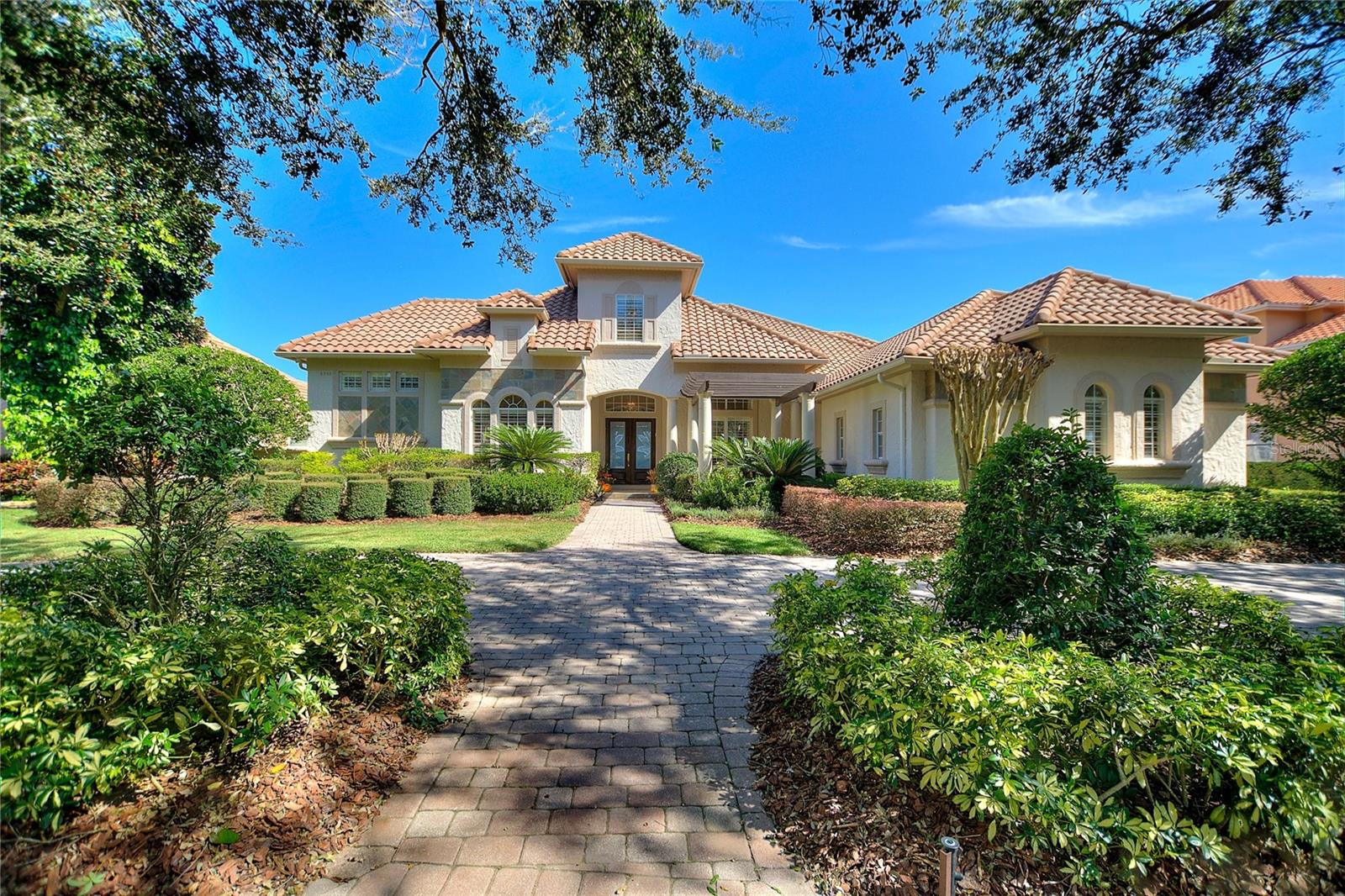 Nestled along the pristine shores of Big Sand Lake in the highly desirable Dr. Phillips community, this 5,562 sq ft, stunning 5-bedroom, 5.5-bathroom luxury home offers an unparalleled combination of elegance, comfort, and scenic beauty. Designed for both luxurious living and entertaining, every corner of this expansive residence exudes sophistication, from the high-end finishes to the thoughtfully crafted spaces that make the most of the idyllic lakefront views. Stepping into this home, you’re immediately welcomed by an impressive grand foyer that sets the tone for the elegance and luxury that awaits. The space is defined by its soaring coffered ceilings, a design element that adds both depth and architectural detail to the room. 
As you walk through the foyer, your gaze is naturally drawn forward to the breathtaking view beyond. Through the formal living room, large floor-to-ceiling windows frame a panoramic vista of the shimmering lake.

The renovated kitchen with granite counter tops has an open-concept layout, which connects the kitchen to the adjoining living and dining areas. 
Tucked away just off the kitchen, the butler’s pantry serves as an essential extension of the culinary space. It’s more than just a storage area—it’s a well-equipped staging space for hosting and entertaining.

  Upon entering the Owner suite, you're immediately captivated by the room's sheer size and its seamless blend of sophistication and comfort. Floor-to-ceiling windows allow natural light to flood the room while offering panoramic views of the shimmering lake.  The attached ensuite bathroom is a masterpiece in its own right, designed with the finest materials and every luxury imaginable.  Now imagine a two-floor master closet that feels more like a private boutique, where luxury meets functionality, and every detail is designed to make getting dressed an indulgent experience. This dream closet is the ultimate statement in both style and organization, offering not only ample storage but also a sense of elegance and personal retreat.

The main floor features three additional bedrooms, each thoughtfully designed to provide comfort, style, and functionality.  The fifth bedroom, located on the upper level, is an ideal teen retreat or nanny suite. This spacious and versatile room with full bath provides a serene escape while still being connected to the heart of the home.
 Installed in 2016 was a new composite wood 115 ft dock and covered boat slip. This dock ensures your vessel is protected from the elements, keeping it sheltered from harsh sun and rain while being easily accessible for spontaneous lake outings.  In addition to the dock, a 100-foot retaining wall or berm was built along the waterfront, serving both a practical and aesthetic function. The retaining wall helps prevent shoreline erosion, protecting the integrity of the property.
   
  This residence on Big Sand Lake is more than just a home—it’s a lifestyle, where every day feels like a vacation. With unmatched views, high-end finishes, and a location in one of Orlando’s most sought-after communities, this luxury property is a rare opportunity to own a piece of paradise. Located in the desirable Dr. Phillips area, this home is minutes away from Orlando’s finest dining, shopping, and entertainment, including Restaurant Row and Walt Disney World.  As an added bonus this home is equipped with a whole home generator.