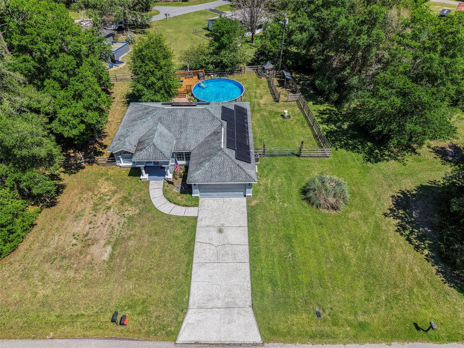 No HOA, large lot, block home - 3-bedroom, 2-bathroom nestled on a 13,275 sqft over a quarter-acre. The spacious kitchen features stainless steel appliances, wood cabinetry, granite countertops, and a large center island with bar seating—perfect for entertaining or casual family meals. The adjacent laundry room offers convenience and quick access to the two-car garage. Split floor plan separates the primary suite from the additional bedrooms. The primary suite has sliding glass doors that leads out to the covered patio. en-suite bath with dual vanities that stretch wall-to-wall, a shower/tub combo, and a custom walk-in closet with built-in shelving. Step outside and enjoy the Florida lifestyle in your fenced backyard oasis, featuring a covered porch with brick pavers, a wooden deck, and an above-ground POOL—ideal for weekend gatherings, relaxing evenings, or family fun. This move-in ready home combines style, functionality, and outdoor enjoyment in one perfect package. Don’t miss your opportunity to own a piece of peaceful Floral City living!