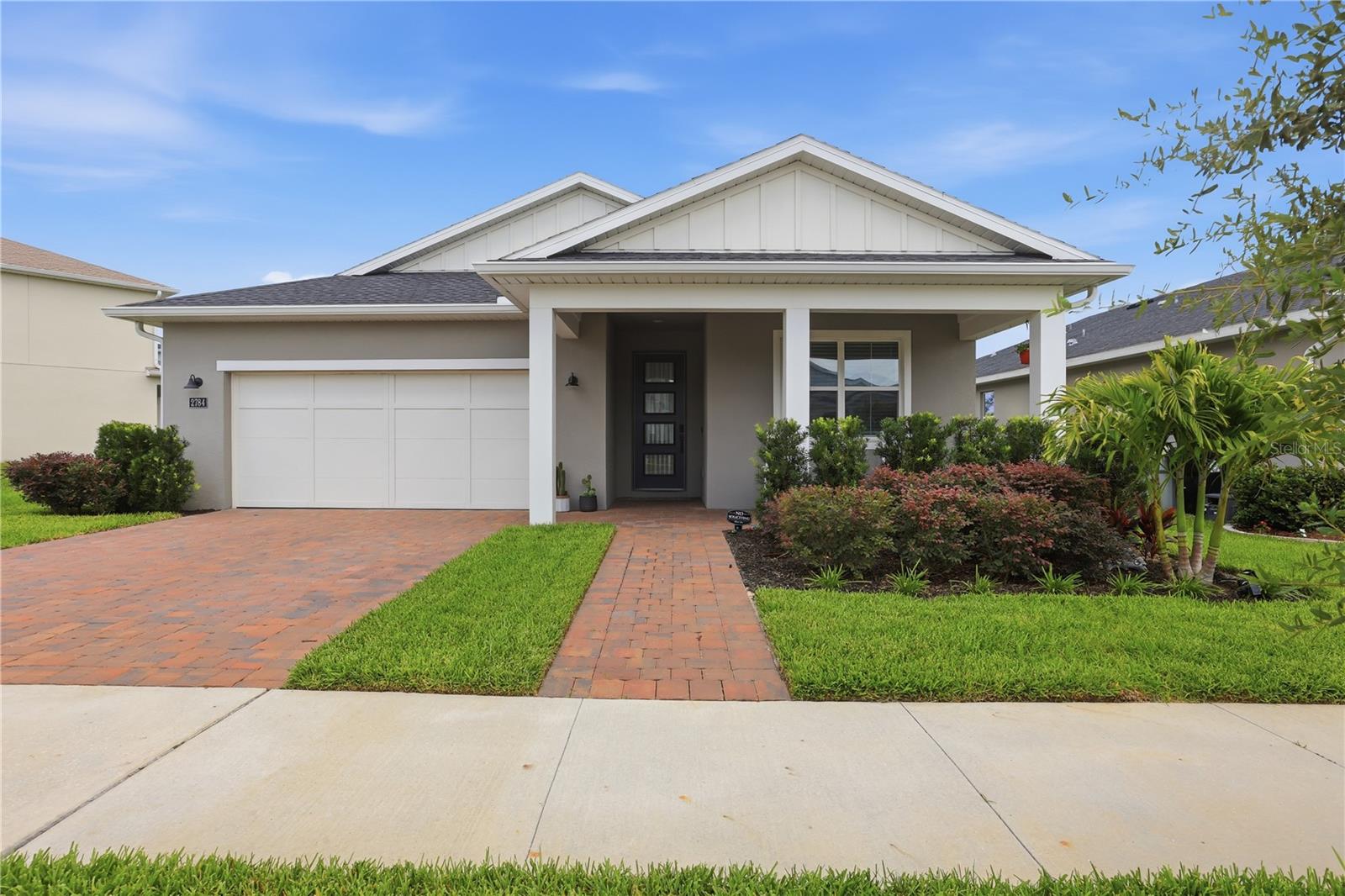 Welcome to this beautifully crafted 3-bedroom, 2-bathroom Raymond model by Toll Brothers, built in 2023 and thoughtfully enhanced with numerous upgrades! From the moment you arrive, the paver driveway and charming covered front porch create a warm and inviting first impression. Step inside to a welcoming foyer highlighted by a stunning statement chandelier that immediately captures your attention. Beyond, the open-concept living space offers beautiful sightlines to the fully fenced backyard with elegant black aluminum fencing, creating the perfect setting for enjoying your morning coffee or relaxing outdoors in the evening. At the heart of the home is a showstopping gourmet kitchen designed to impress! The oversized quartz island features a striking black-and-white pattern that serves as a true centerpiece, complemented by a designer mosaic tile backsplash, upgraded cabinetry, glass pendant lighting, stainless steel appliances, a natural gas cooktop with a vented hood, and a spacious walk-in pantry accented by a frosted glass door. The kitchen flows seamlessly into the dining area and expansive living room, creating an ideal space for entertaining and everyday living. An electric decorative fireplace adds warmth and character to the open-concept gathering area. The spacious primary suite features a large walk-in closet and a spa-inspired bath complete with quartz countertops, designer tile flooring, soaking tub, separate shower, and private water closet. Two additional bedrooms and a beautifully appointed guest bathroom with granite countertops and floor-to-ceiling tile in the shower/tub combination provide comfort and flexibility for family, guests, or a home office. Additional upgrades include an EV outlet in the 2-car garage for an electric car, water purification system, gutters, lighting fixtures, ceiling fans, electric fireplace, white faux-wood blinds, landscaping, a smart Kwikset front door lock, and soft-close toilets. Ideally positioned on a spacious homesite with convenient guest parking nearby and a scenic walking trail just steps away, this exceptional single-story split floor plan offers both luxury and convenience. Residents enjoy access to resort-style amenities including a community pool, splash pad, dog park, community mailbox, and picturesque walking paths. Located just minutes from SR 429, Kelly Park/Rock Springs, Lake Apopka, and the highly anticipated Wyld Oaks development, you'll enjoy easy access to recreation, dining, shopping, entertainment, and everyday conveniences. Move-in ready and loaded with upgrades, this exceptional home offers the perfect combination of modern elegance, comfort, and community living. Welcome home!