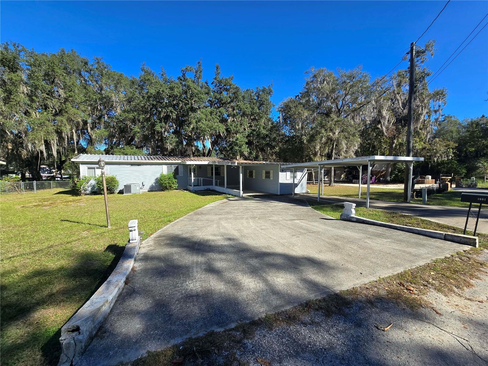 Discover affordable waterfront living on this .32 acre lot in beautiful Silver Springs! Nestled among peaceful natural areas, shimmering lakes, and abundant wildlife, This 1978 manufactured  home (with later upgrades) offers the perfect opportunity to create your dream getaway, full-time residence, or investment property.This property has a split plan making it an ideal winter retreat for two couples who love to fish, kayak, walk, bycycling, and just enjoy nature. This neighborhood is surrounded by the Ocala National Forest, yet close to all the amenities and attractions Ocala has so you will never run out of fun things to do. New central a/c, new water heater and new laminate flooring. Large enclosed back porch overlooking the water. Attached storage building, multiple carports and 2 concrete driveways. Dock and boathouse on site 
This home is in nice condition overall with lots and lots of extra features!! Come and take a look today! Financing is available.
