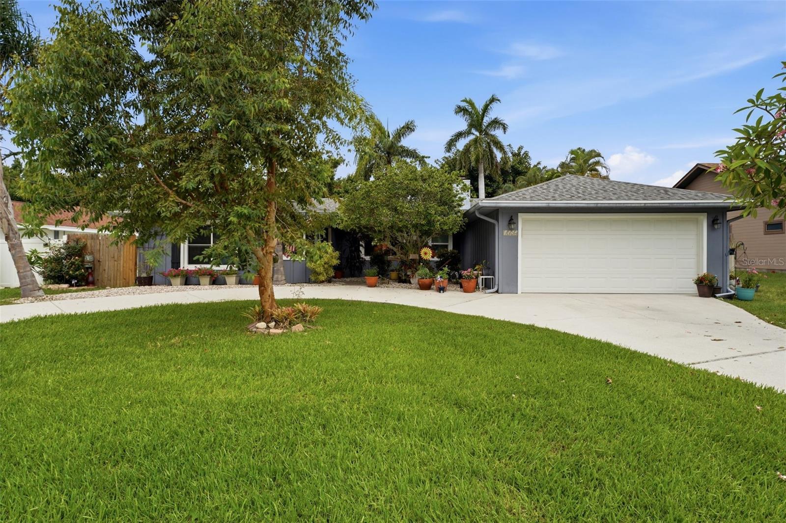Welcome to your private tropical oasis in highly desirable Northwest Bradenton! Tucked away on a quiet, peaceful dead-end street of only 10 homes, this spectacular 3-bedroom, 3-bathroom pool home offers 2,519 square feet of beautifully designed, split-floorplan living space—with no HOA or CDD fees. Pass through the charming entryway alcove featuring a stunning stained-glass window to find a spacious living room centered around a magnificent floor-to-ceiling, wood-burning flagstone fireplace, custom built-in bookshelves, and elegant plantation shutters. Beautiful tile flooring runs seamlessly throughout the home for low-maintenance coastal living. The true showstopper of the home awaits through triple French doors: a massive, custom-built family room featuring soaring vaulted ceilings and four sun-drenched skylights. Designed for the ultimate Florida lifestyle, the sidewalls are almost entirely glass and slide wide open to seamlessly transform the room into an open-air, cabana-style entertaining hub. On one side, it overlooks a sprawling deck perfect for grilling; on the other, it opens up to a resort-style swimming pool finished with smooth bull-nose brick edging and a tranquil water feature. The fully fenced backyard is a lush sanctuary, complete with mature palms and fragrant plumeria trees. Retreat to the expansive primary suite, boasting a spacious walk-in closet, an en-suite bath with dual sinks, a walk-in shower, and dedicated laundry convenience. Sliding glass doors from the primary bedroom open directly to an intimate private garden alcove. Two additional generously sized bedrooms and baths are thoughtfully spaced out to ensure maximum privacy for family or guests. Incredible practical highlights bring ultimate efficiency and peace of mind to this property, featuring fully paid-off solar panels. Additionally, you'll find an attached 2-car garage, plus a sprawling circular driveway providing ample parking. Located just minutes from top-rated schools, local boat ramps, the pristine beaches of Anna Maria Island, and Robinson Preserve. Don’t miss your chance to own this custom Bradenton gem—schedule your private tour today!