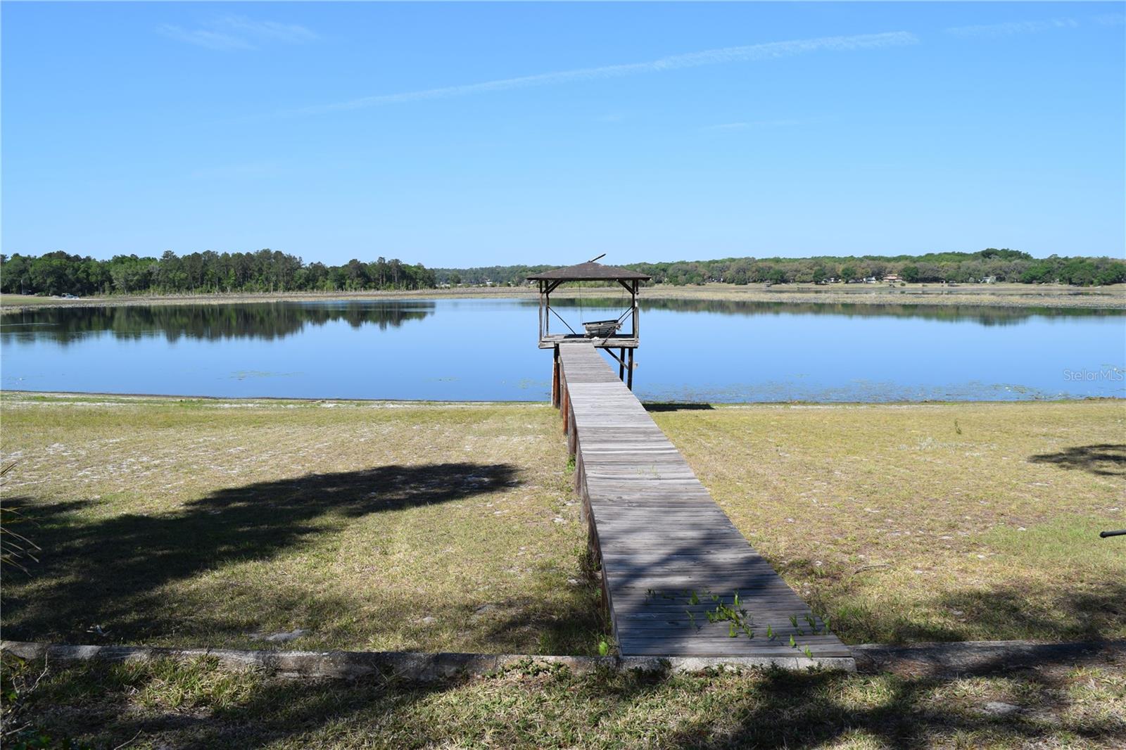 Paradise on the lake.  3 bedroom 2 bath home with fireplace.  Kitchen looks out to lake along with formal dining area and laundry area.  Concrete picnic table under the trees to enjoy the view.  Large workshop 24 x 27 with storage and attic.  Living room windows have glass shelves.  Large workshop with lots of storage.  Drought has lake low and roads are soft.