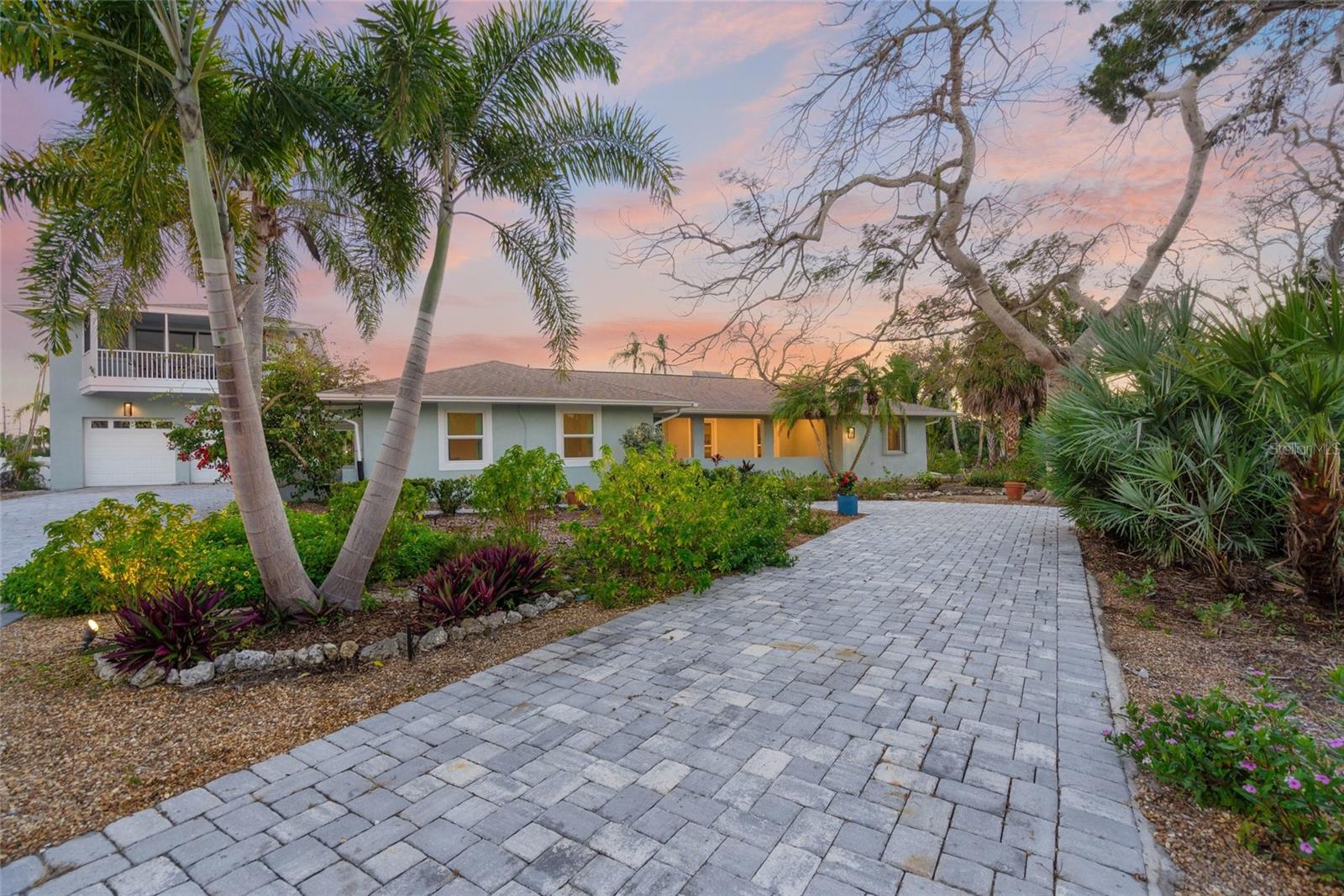 You can smell the salty Gulf breeze the moment you arrive—an unmistakable reminder that this is not just a home, but a rare opportunity to live steps from world-famous Siesta Key Beach with deeded beach access in one of the island’s most exclusive enclaves. Welcome to 8560 Heron Lagoon Circle, a completely reimagined Arthur Rutenberg estate in the private, boutique community of Heron Lagoon Lodges—where only 13 residences share a setting of privacy, prestige, and coastal elegance.

Positioned on more than half acre and framed by lush tropical landscaping, this exceptional property blends timeless architecture with sophisticated, modern upgrades. The expansive paver driveway and gated presence create an impressive arrival, while the home’s light coastal exterior and elevated design reflect the relaxed luxury of Siesta Key living. Inside, the residence has been thoughtfully renovated with clean lines, wide-plank flooring, designer lighting, and curated finishes that feel both contemporary and enduring.

The heart of the home is a stunning, fully updated chef’s kitchen featuring sleek custom cabinetry, striking waterfall-edge countertops, high-end appliances, and a dramatic oversized island designed for gathering. A designer backsplash, under-cabinet lighting, and refined hardware elevate the space, seamlessly flowing into open-concept living and dining areas bathed in natural light. Large sliders invite the outdoors in, creating effortless indoor-outdoor living—ideal for entertaining after a day on the beach.

The extended primary suite is a true private retreat, offering generous proportions, serene views, and a spa-inspired bathroom with dual vanities, modern fixtures, and a luxurious walk-in shower. Additional guest bedrooms are equally refined, while a temperature-controlled wine room adds a sophisticated touch for collectors and entertainers alike.

Outdoors, the screened lanai and resort-style pool create a private sanctuary surrounded by mature palms and tropical greenery. Whether hosting sunset dinners under the covered patio or enjoying quiet mornings by the water, the backyard embodies the essence of Florida luxury living. Just beyond the main residence, a newly added detached garage with a guest house above offers exceptional flexibility—perfect for visitors, a private office, or multigenerational living.

Located in the heart of Siesta Key, this exclusive community offers deeded beach access to the powdery white sands and turquoise waters that have made Sarasota one of Florida’s most desirable coastal destinations. With only 13 homes in Heron Lagoon Lodges, privacy and tranquility are preserved, while fine dining, boutique shopping, and vibrant island culture remain just moments away.

Completely remodeled, impeccably maintained, and positioned in one of Siesta Key’s most coveted settings, this is a rare opportunity to own a luxury coastal estate where modern refinement meets effortless beachside living.
