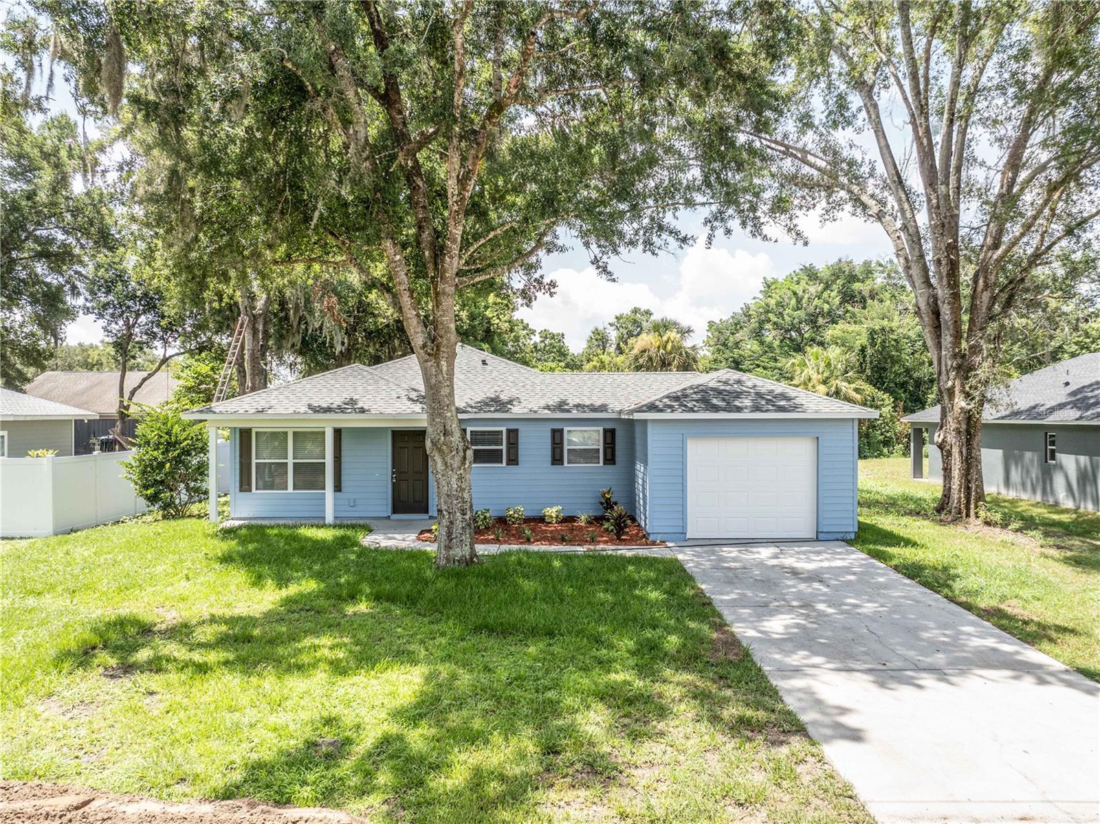 Welcome home to this beautifully updated 3-bedroom, 1.5-bath residence in the heart of Eustis! Nestled beneath mature shade trees on a spacious lot, this charming home offers great curb appeal with fresh landscaping, a welcoming front porch, and an attached one-car garage.
Inside, you'll find an open and inviting floor plan featuring luxury vinyl plank flooring, abundant natural light, and a neutral color palette ready for your personal touch. The spacious kitchen is equipped with ample cabinetry, generous counter space, and new appliances, flowing seamlessly into the dining and living areas—perfect for both everyday living and entertaining. Just off the kitchen, you'll appreciate the convenience of a dedicated indoor laundry room with additional storage space. The home's three comfortable bedrooms provide flexibility for family, guests, or a home office, while the full bath and convenient half bath add everyday functionality. Step outside to enjoy the large backyard with plenty of room for pets, play, gardening, or future outdoor entertaining. Conveniently located near shopping, dining, schools, parks, and major roadways, this move-in ready home offers the perfect combination of comfort, convenience, and value. Whether you're a first-time homebuyer, downsizing, or looking for an investment opportunity, this Eustis gem is one you won't want to miss!