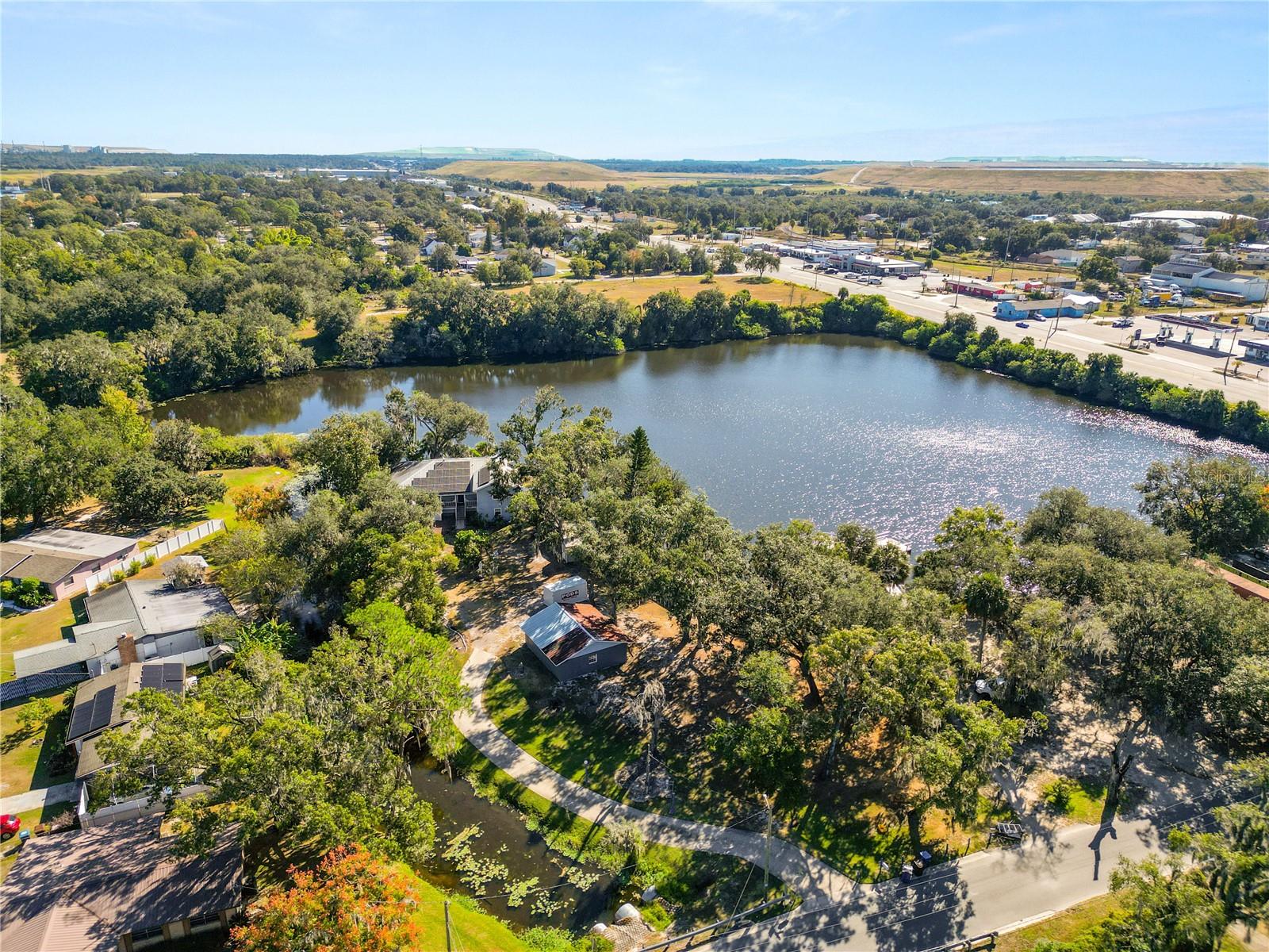 NEW PRICE AND NEW WATERFRONT OPPORTUNITY!  Florida waterfront private living just became More Attainable! Wake Up to Water Views and Wildlife, Boat Days, Sunset Nights! Repositioned for the new owners!  RARE WATERFRONT ESTATE ON NEARLY 7 ACRES | MAIN HOME + GUEST HOUSE Discover a truly unique triple-level waterfront retreat offering nearly 7 private acres of land and water, designed for privacy, nature, and year-round outdoor living. A long private circular drive leads to this secluded sanctuary surrounded by sparkling water and abundant wildlife. The main residence features 3 bedrooms and 2.5 baths, with expansive windows, skylights, and multiple living areas capturing breathtaking water views. The chef’s kitchen offers generous workspace and a sun-filled eat-in nook overlooking the water. A bright sunroom extends the living space, perfect for relaxing or entertaining. The main level includes a formal dining room with built-in shelving (ideal as a study), half bath, and a large interior utility/storage room that can also function as a home office. The lower level hosts the family room/den and the primary suite, both offering direct water access and waterfront views. Upstairs are two spacious bedrooms, a guest bath, and additional attic storage. A separate guest home at the front of the property—currently under renovation—offers excellent flexibility for multi-generational living, guests, or income potential, while maintaining privacy between residences. Ideal for fishing, kayaking, canoeing, and enjoying the outdoors, with room for boats, RVs, and recreational toys. Conveniently located near shopping and dining, with Mulberry Dock & Park adjacent to the property. A rare opportunity to own a private waterfront estate—schedule your private showing today.