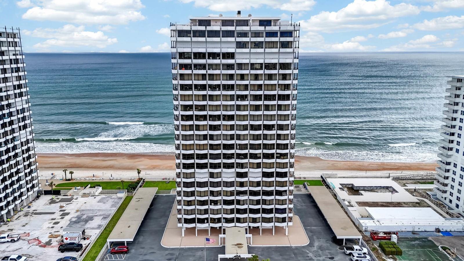 Experience refined coastal living at the prestigious Aliki in this meticulously updated 18th-floor residence where panoramic views extend from the Halifax River to the Atlantic Ocean. This highly sought-after southern exposure center unit offers expansive ocean vistas stretching for miles, complemented by sparkling river and skyline views to the west. Floor-to-ceiling windows and sweeping balcony access create an exceptional setting for appreciating breathtaking sunrises and the ever-changing beauty of the coastline. interior with abundant natural light while showcasing remarkable sunrises over the Atlantic and striking sunsets across the Intracoastal Waterway. A 76-foot wraparound private balcony, accessible from every room, further enhances the seamless indoor-outdoor living experience. Additional highlights include captivating moonrises, rocket launches, and frequent sightings of dolphins, sea turtles, coastal birds, and whales, all visible from the comfort of the residence. The open-concept living and dining areas provide an inviting environment ideally suited for both entertaining and everyday living. The designer kitchen is equally impressive, featuring custom cabinetry, granite countertops, stainless steel appliances, and refined finishes that complement the residence's sophisticated coastal aesthetic. This exceptional property represents far more than a residence; it offers a rare opportunity to experience the beauty of the Atlantic through a lifestyle distinguished by luxury, tranquility, and extraordinary views. Schedule your private showing today and discover firsthand the unmatched elegance, comfort, and breathtaking coastal scenery this exceptional Aliki residence has to offer. All information taken from the tax record, and while deemed reliable, cannot be guaranteed.