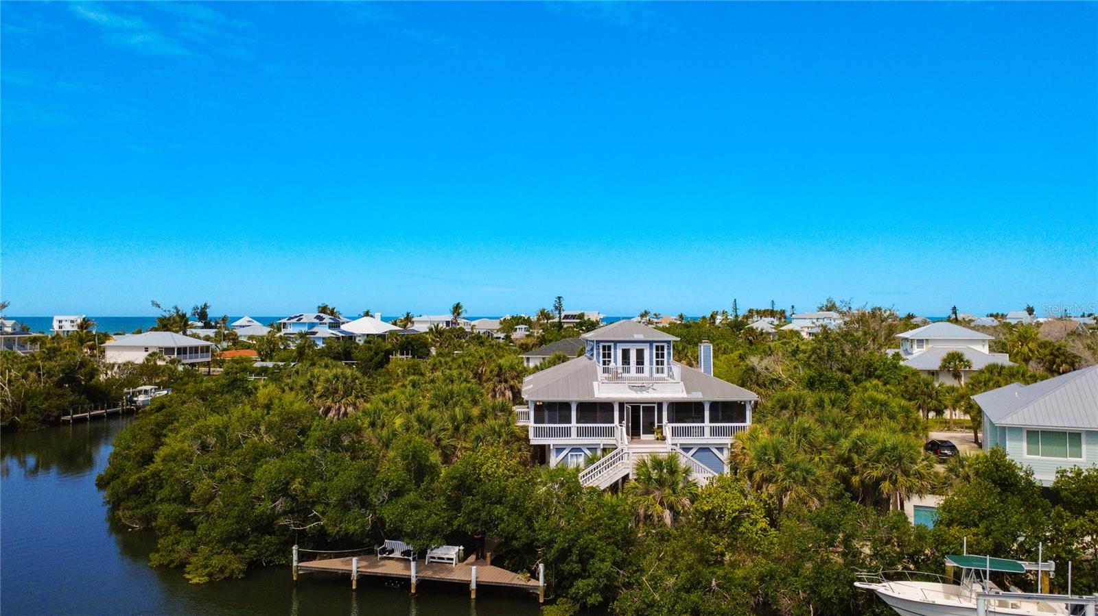 HIGH and DRY!! This home stands tall on top of pilings over 15 feet!! The most recent storm showed zero water damage. Not a single drop of saltwater touched it. 

With just a short ferry ride. You are a 5 minute golf cart ride to a miles long private beach.

Welcome to an exceptional private waterfront estate offering over 100 feet of direct deep-water frontage with immediate, no-bridge access to the Intracoastal Waterway (1 minute) and the Gulf (10 minutes)—an ideal setting for the discerning boating enthusiast.

This beautifully maintained 3-bedroom, 2-bath coastal residence is thoughtfully designed for refined yet relaxed Florida living. Soaring vaulted ceilings and an open-concept layout create a light-filled interior, while the spacious living area—anchored by a wood-burning fireplace—offers an inviting space for both intimate gatherings and effortless entertaining. The well-appointed kitchen with granite countertops flows seamlessly into the main living areas.

Embrace true indoor-outdoor living from the expansive wraparound screened porch, where panoramic water views and gentle coastal breezes provide a serene, ever-changing backdrop. The upper-level primary suite serves as a private sanctuary, complete with its own balcony overlooking the bay—perfect for morning coffee or sunset unwinding.

Set on an oversized, lushly landscaped homesite, the property offers exceptional privacy and ample space to create a custom pool and outdoor living oasis. A private dock with deep-water access completes this boater’s retreat, accommodating a variety of vessels with ease. The waterfront setting is also ideal for fishing off your dock, paddle boarding and kayaking, offering effortless access to calm waters and an immersive coastal lifestyle right from your own backyard.

Enhancing its sense of seclusion, this unique island setting is accessible only via a short drive, private ferry, or personal boat—offering a rare blend of convenience and exclusivity that defines true coastal luxury.

The community is also golf cart friendly, allowing for relaxed and convenient travel throughout the island-style setting, adding to the laid-back yet upscale coastal lifestyle. Additionally, there are no HOA fees, providing greater flexibility and fewer restrictions while maintaining the area’s serene and well-kept character.

Ideally located just minutes from Boca Grande and some of Southwest Florida’s most pristine beaches, this residence offers a rare combination of seclusion and convenience, with access to world-class fishing, fine dining, and upscale coastal amenities.

In addition to its appeal as a private residence, the property presents excellent potential as a high-end vacation rental, with strong demand for waterfront homes offering direct Gulf access and no minimum rental restrictions creating an opportunity for meaningful supplemental income when not in personal use.

Whether as a primary residence, luxury retreat, or income-producing investment, this is a rare opportunity to own a premier piece of Florida waterfront living.