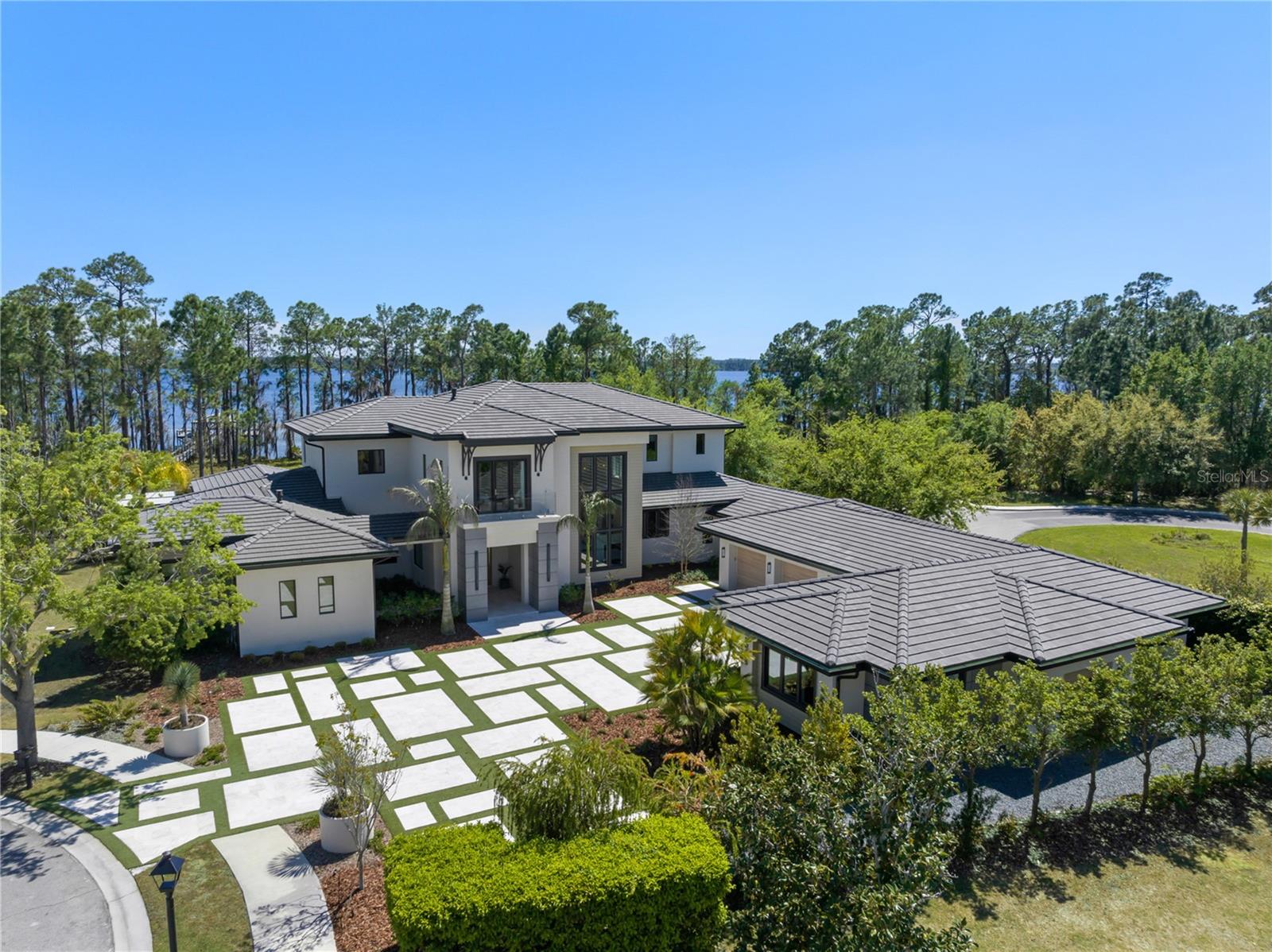 Introducing One of the Most Remarkable Lakefront Estates in Lake Nona Golf & Country Club. Positioned on approximately 3/4 of an acre along the shores of Lake Nona, this newly completed (2024) custom estate represents a rare opportunity to own one of the most compelling lakefront properties ever offered within the gates of Lake Nona Golf & Country Club. With approximately 130 feet of shoreline, the property captures expansive water views while offering a true sense of privacy and scale. Set at the end of a private cul-de-sac, the residence provides direct access to the 587-acre private lake and features a dock, boathouse, and lift—delivering a waterfront lifestyle that is nearly impossible to replicate within the community. 8506 Lake Nona Shore Drive is custom residence that seamlessly blends timeless architecture with true resort-style living. Built by DeVoe Custom Homes with interiors curated by Jorje Design of Chicago, the 8,000+ square foot residence is thoughtfully designed for both everyday living and elevated entertaining. The floor plan features two primary suites and a separate casita with private entrance, full bath, and kitchenette—ideal for guests or multi-generational living. Inside, a dramatic foyer with a double-sided gas fireplace creates a striking focal point between the living room and chef’s kitchen. The kitchen is equipped with Sub-Zero and Wolf appliances, complemented by a walk-in prep kitchen, and flows seamlessly into the family room, where corner pocket sliding glass doors open to create a true indoor-outdoor experience. The first-floor primary suite serves as a private retreat, complete with a morning bar, custom remote-controlled window treatments, and expansive sliders that fill the space with natural light. The spa-inspired primary bath features dual water closets and an oversized custom closet with dedicated laundry. Upstairs, a spacious loft provides additional living space, while four secondary bedrooms include a second primary-style suite with private living area, breakfast bar, and access to a covered balcony overlooking the lake. The upper level also includes a second laundry room and is pre-plumbed for a future elevator. Outdoor living is equally impressive. A covered lanai with retractable screens connects to a fully equipped summer kitchen with a 54” Viking grill, refrigerator, and sink. The custom pool by Paradise Pools features a 75-foot lap lane, oversized sun shelf, spa, and water features—creating a true resort-caliber setting. A dedicated pool bath adds convenience for entertaining and everyday use. Additional features include smart home automation, a spacious mudroom with a third laundry area, and a five-car garage with approximately 350 square feet of climate-controlled storage. With its combination of new construction, expansive lakefront setting, and resort-level amenities, this is a rare opportunity to own one of the finest and most complete properties within Lake Nona Golf & Country Club. Opportunities of this scale and positioning on Lake Nona are exceptionally limited and rarely come to market.