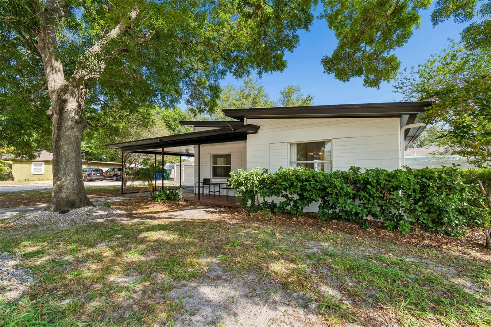 Situated on a spacious 70x103 corner lot, this charming mid-century modern cottage offers a functional floor plan, inviting indoor-outdoor living, and peace of mind with solid block construction and having not flooded during the 2024 storms. Spend your summer evenings strolling through this quiet neighborhood to Dairy Joy for ice cream and experience the best of South Tampa living. You’ll first be drawn in by the clean architectural lines, mature oak trees, and the inviting front porch. Inside you will find a great floor plan featuring formal living and dining rooms, a spacious family room overlooking the backyard through large picture window, breakfast bar in kitchen, two bedrooms and one bathroom conveniently located in the hallway between them, and a screened in 9x13 lanai for additional outdoor living space. The low-maintenance turfed and fully-fenced backyard is thoughtfully designed with a storage shed and pavilion, offering plenty of space to entertain, unwind, or play year-round. Located just minutes from local gems, with shopping and dining options abound, and near major thoroughfares including West Shore, Gandy, Dale Mabry, and the Selmon Expressway. This home perfectly combines convenience with neighborhood charm. Schedule your private tour and make it yours today!