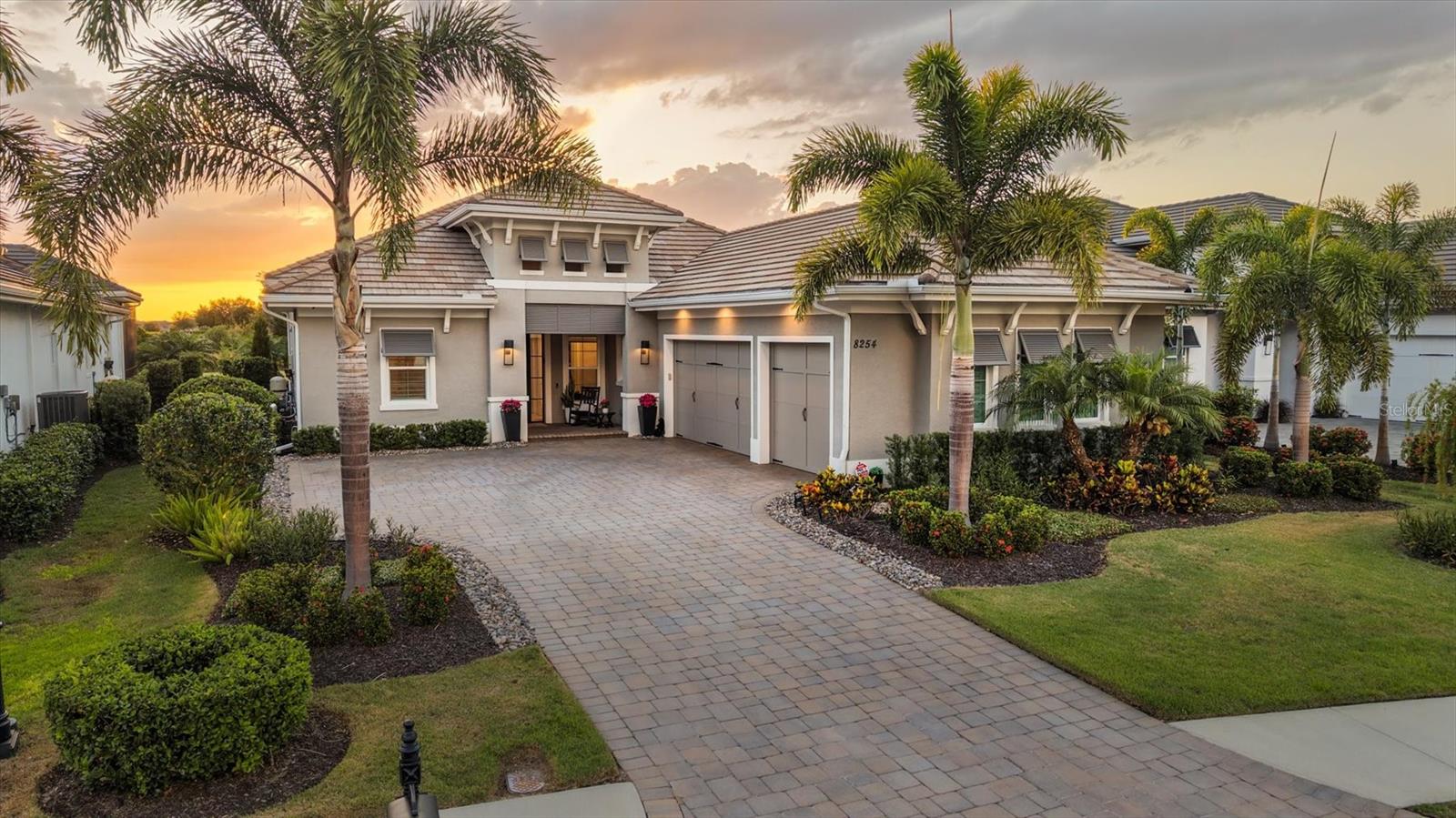 Behind the gates of The Lake Club in Lakewood Ranch, this Stock-built Mayfield III residence delivers the level of refinement, comfort, and lifestyle buyers expect from one of Lakewood Ranch’s premier luxury addresses. Offering 4 bedrooms, 3 full baths, 1 half bath, 3,033 square feet of air-conditioned living space, and 4,469 square feet under roof, this home was designed for elegant Florida living with a thoughtful balance of indoor comfort, outdoor privacy, and high-end functionality.
From the moment you arrive, the home makes a strong first impression with its elegant architectural design, upgraded front entry, lush tropical landscaping, and paver driveway. Inside, custom wood detailing and decorative beams enhance the tray ceilings, adding warmth and architectural character, while smart Lutron lighting creates a more refined and convenient living experience throughout the home. The fitted-out closets provide a tailored level of organization, and the electric blind in the primary suite adds both privacy and ease.
The west-facing lanai is one of the home’s standout features, offering a private preserve view and a saltwater heated pool and spa designed for relaxing, entertaining, and enjoying Lakewood Ranch sunsets. Whether it is a quiet evening outside or a weekend gathering with guests, the outdoor living space feels private, polished, and connected to the natural setting.
Beyond the visible finishes, this home has been upgraded with features that are rarely noticed at first glance but are highly valued at this level of the market. A whole-house generator provides added peace of mind, while the home water filtration system supports a higher standard of everyday living. The garage has also been thoughtfully improved with insulation, a mini-split air-conditioning system, and EV chargers, creating a cleaner, more comfortable, and more functional space for vehicles, storage, fitness, or hobbies.
The Lake Club is one of Lakewood Ranch’s most prestigious guard-gated communities, offering an elevated lifestyle with resort-style amenities including an on-site restaurant and bar, two swimming pools, tennis, pickleball, and a fitness center. The location also places you close to some of the best beaches in the country, UTC Mall, SRQ Airport, Sarasota, and Tampa, making it easy to enjoy everything the Gulf Coast has to offer.
Every upgrade feels intentional, from the smart-home features and ceiling details to the pool, spa, preserve view, generator, filtration system, enhanced garage, and premier community setting. This is a home designed not just to impress, but to live exceptionally well.