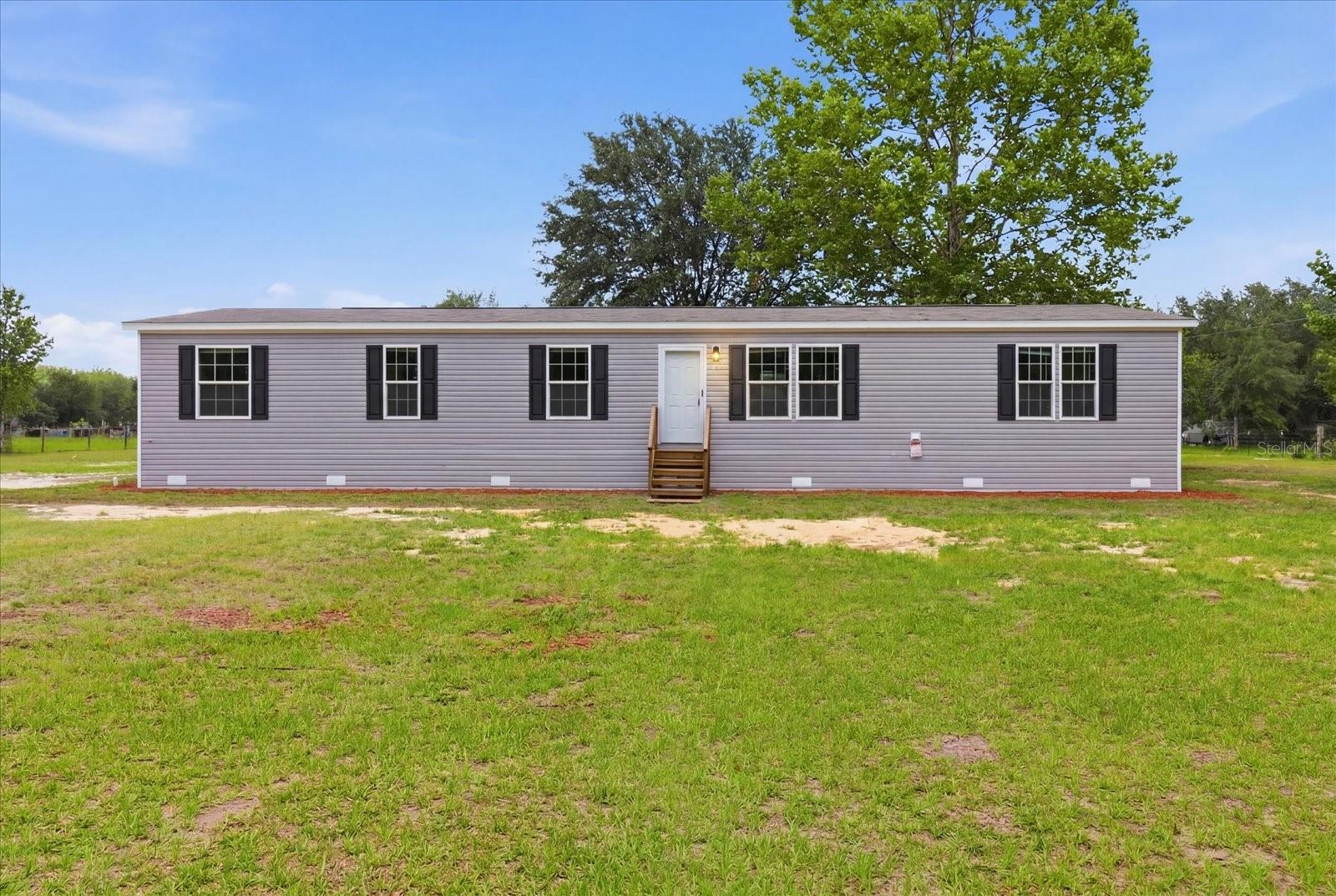 Pre-Construction. To be built. Welcome to your dream home, that sits on over an acre lot! This beautifully designed 5-bedroom, 2-bathroom brand-new manufactured home offers a spacious, 3 acres of high and dry land with plenty of privacy and no HOA. Open floor plan ideal for modern living. From the moment you step inside, you’ll appreciate the high-quality finishes and attention to detail with vinyl flooring throughout. The spacious living room seamlessly flows into the kitchen and dining area, perfect for entertaining guests. The master bedroom is a serene retreat, with a luxurious en-suite master bath with shower and a walk-in closet. The chef-inspired kitchen is equipped with brand-new stainless steel appliances, featuring a central island with a breakfast bar, shaker-style cabinets, and a pantry. The added family room provides even more space to spread out, whether you need a home office, playroom, or second living area. Three additional bedrooms provide plenty of space for family members or guests. The second bathroom offers a tub, perfect for unwinding after a long day. Additionally, the utility room is a great space for laundry and storage, adding to the home’s overall convenience. You are minutes away from the Ocala National Forest, world-class fishing on Orange Lake, and the crystal-clear waters of Salt Springs. With plenty of room for your RV, boats, and ATVs, this is more than a home—it’s a gateway to North Central Florida’s best hiking, hunting, and trail riding. Come see why Fort McCoy is the hidden gem of Marion County!