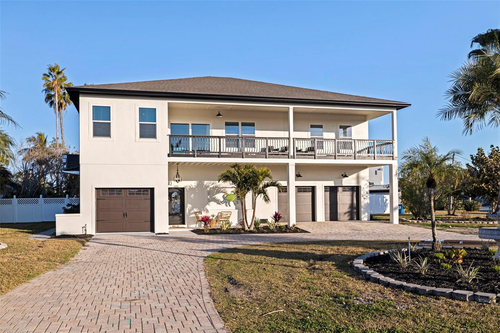This home has already been appraised and priced accordingly! Giving a fantastic combination of quality, value and confidence that the home is priced with current market in mind! Welcome to coastal living done right on Isle of Palms in Treasure Island. This brand-new, elevated 4 bedroom, 2 bath home was built from the ground up with both lifestyle and peace of mind in mind. The most important feature, the home is ELEVATED and FEMA compliant, allowing you to truly enjoy the waterfront lifestyle without the worry of flooding!
Perfectly positioned on an oversized corner lot, you’ll enjoy sparkling water views from the front and back of the home. Wake up to sunrise over the water and unwind with sunset skies in the evening. You have water voews from every bedroom and can even see panaramic views of holiday fireworks! Inside, the open floor plan features vaulted ceilings, luxury vinyl plank flooring, and high-end finishes throughout. A wall of triple sliding glass doors creates seamless indoor-outdoor living, and frame the beautiful waterway views. The chef’s kitchen flows effortlessly into the main living and dining areas, making the home ideal for everyday living or entertaining. Outdoor living is where this property truly shines, offering over 900 sq ft of covered patio space on the front and back of the home. Plus a new pavered pool deck and expansive backyard. An ELEVATOR provides easy access to the second floor, so no need to worry about hauling your groceries or your beachbags up the stairs! and the oversized 3-car garage offers abundant storage along with flexible space perfect for a game room, gym, workshop, or additional entertaining area.  New construction, elevated design, water views on both sides, and a location just blocks to the beach — this is a rare opportunity to own a thoughtfully built coastal home that combines luxury, functionality, and the ultimate Florida waterfront lifestyle!