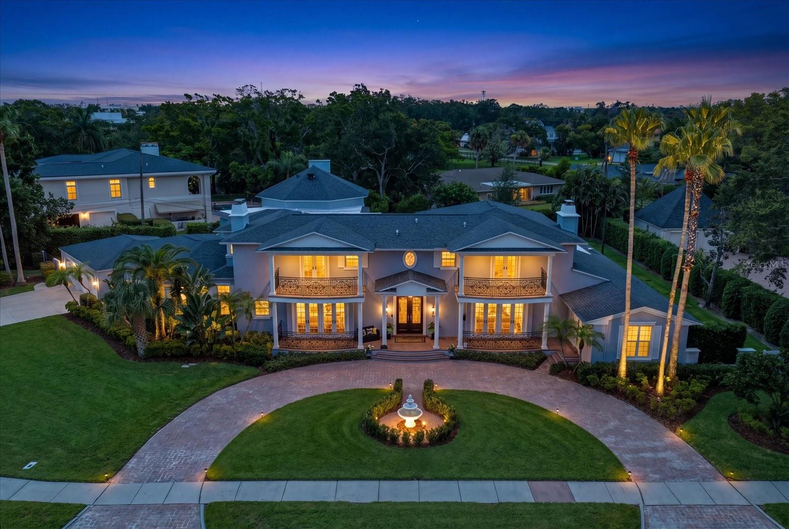 A truly exceptional opportunity awaits in Belleair's prestigious Willadel subdivision. Situated high and dry on two-thirds of an acre, this magnificent 7,500+ square-foot estate offers 7 bedrooms, 6.5 baths, a 3-car garage, and access to an exclusive private waterfront park featuring a newly remodeled boat basin. The deeded boat slip with a newer dock and 13,000-pound boat lift provide direct access to the Intracoastal Waterway and Gulf. Arriving via the circular driveway, you'll immediately appreciate the timeless Southern-inspired architecture and grand presence of this remarkable residence. A sweeping staircase welcomes guests through the double-door entry, setting the stage for the elegant living spaces beyond. 155 Willadel was designed with both entertaining (this home has hosted a number of prestigious events) and family living in mind. The gourmet kitchen is equipped with double islands, Wolfe, Subzero and Thermador stainless steel appliances, extensive custom cabinetry, and luxury stone countertops. Adjacent to the kitchen, the expansive great room offers soaring 20’ ceilings, a gas fireplace, and a climate-controlled wine room. Also downstairs is a formal dining room with adjoining butler's pantry, a gracious living room with custom built-ins, wood-burning fireplace, hardwood flooring, crown molding, and two sets of French doors that open to a charming front veranda. Four downstairs bedrooms – two en-suite and two sharing a jack and jill bath – provide plenty of comfortable space for family and guests. Upstairs can be accessed by front or back staircases, as well as an elevator, where you will find 3 oversized bedrooms, all of which are en-suite. The primary features a private balcony, two large walk-in closets and a beautiful remodeled primary bath with soaking tub and separate shower. One of the other upstairs bedrooms has a wood-burning fireplace, private balcony, and spacious walk-in closet. Both upstairs balconies have peeks of the intracoastal. Additional amenities include upstairs and downstairs laundry rooms, a private theater room with projector and large screen, a wet bar, game room, and numerous custom built-ins throughout. The flexible floor plan provides abundant space for family, guests, and entertaining. Outdoor living is equally impressive, featuring a covered lanai with a spectacular outdoor kitchen overlooking the spacious, private backyard lined with mature podocarpus. The property’s RE (Estate Residential) zoning classification and large backyard allow for the construction of an additional structure as well as ample room for a resort-style pool. Other recent upgrades include impact-rated windows and doors throughout, a completely replumbed home, updated electrical throughout, and a whole-house generator for added comfort and peace of mind. Located just minutes from Clearwater Beach, fine dining, boutique shopping, and premier golf destinations including Belleair Country Club and Pelican Golf Club, this extraordinary estate presents a rare opportunity to enjoy luxury living in one of Florida's most sought-after boating, golf, and racquet communities.