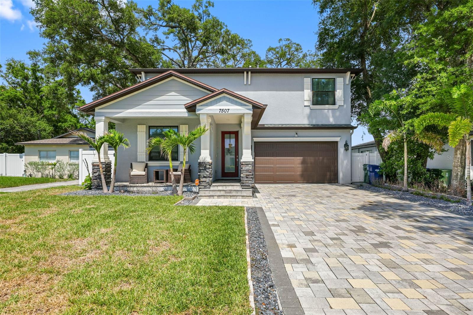 Welcome to this beautifully upgraded contemporary residence in the heart of Old Seminole Heights, one of Tampa Bay’s most sought-after neighborhoods. Nearly new and meticulously maintained, this exceptional 4-bedroom, 3-bathroom home with a 2-car garage offers over 3,200 square feet of thoughtfully designed living space that perfectly blends elegance, comfort, and modern Florida living. From the moment you enter, you'll appreciate the attention to detail and extensive upgrades throughout. The first floor features stylish SPC laminate flooring (2022), while the staircase and entire second level are enhanced with plush new carpeting (2025), creating a warm and inviting atmosphere. The spacious living area is highlighted by a custom stone media wall, adding sophistication and character to the heart of the home. The designer-inspired kitchen is a true showpiece, featuring upgraded appliances, stunning stone countertops, a new sink, and an expanded center island that serves as the perfect gathering place for family and friends. Whether preparing meals or entertaining guests, this space is designed to impress. Upstairs, retreat to the expansive primary suite, a private sanctuary complete with dual walk-in closets and a spa-inspired en-suite bath featuring a state-of-the-art freestanding soaking tub and separate walk-in shower. An additional bedroom has been enhanced with a custom closet system, offering both beauty and functionality with adjustable organization. Step outside and enjoy Florida living at its finest. The front and rear porches, newly added backyard entertainment patio, and elegant outdoor lighting create the ideal setting for relaxing evenings or hosting guests. The generously sized backyard also offers ample room to personalize and create the outdoor oasis of your dreams. Additional upgrades include fresh interior paint completed in 2022, a new HVAC system installed in 2023, and a suite of upgraded kitchen appliances—including the refrigerator, range, microwave, and dishwasher—added between 2023 and 2024. The home also features a new washer and dryer (2024), a tankless water heater installed in 2025, and a full security system, providing added convenience, efficiency, and peace of mind for years to come. This property is located right next to I-275 offering a direct 10 minute drive to downtown Tampa and Tampa International Airport. Do not miss out and book your showing today!