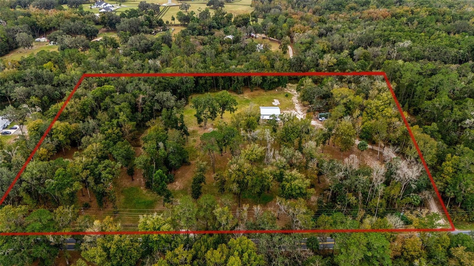 Discover 10 breathtaking acres in highly sought-after SE Marion County—perfectly positioned for your dream home, farm, or private retreat. This beautifully maintained property offers an ideal blend of cleared land and shaded wooded areas, highlighted by grand live oaks, an open cleared area ready to build, and natural privacy throughout. 
The land is already improved with water and power on site, a large storage workshop, perimeter fencing, and newly sodded grass. A grand gated entrance with a driveway apron plus an additional side entrance provides both convenience and curb appeal. An active spring on the property adds a rare, charming natural feature.
A standout feature of this property is the expansive cleared homesite already in place. Large enough for an approximately 5,000-square-foot home plus garage, the site is ready for construction while preserving the property's beautiful mature trees and natural character. It's rare to find acreage that offers both a build-ready homesite and the privacy, shade, and beauty of established oaks. Save the time, cost, and uncertainty of clearing land while still having plenty of room to expand and customize the property to your needs.
Location is truly unbeatable—just 5 minutes to the Florida Horse Park, 10 minutes to Belleview, 20 minutes to Downtown Ocala, 30 minutes to the World Equestrian Center, and walking distance from the Santos Biking, Hiking and Equestrian Trails.
A well-balanced, ready-to-build property with character, convenience, and beauty—this is the kind of land that doesn’t come around often. The property has been recently appraised, offering added confidence in value.