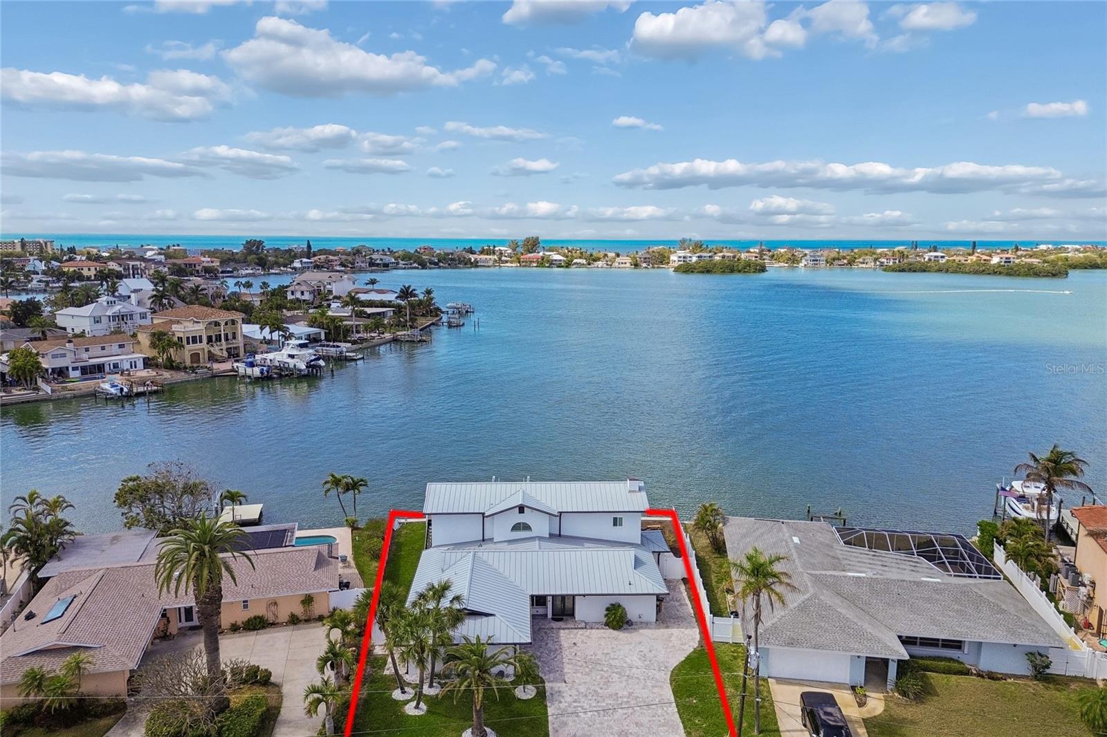Experience the pinnacle of the Indian Rocks Beach waterfront lifestyle in this beautifully updated coastal retreat, where luxury, boating, and income potential come together on one of the area’s most desirable open water lots. Inside, This spacious home features 4 bedrooms, each with a private en-suite bathroom and an open floor plan designed to maximize the stunning water views in every major living area. Recent 2025 upgrades elevate the home with durable wood-look tile flooring, all-new custom kitchen cabinetry, designer countertops, and high-end appliances. The second floor leads to a serene primary suite sanctuary, offering soaring ceilings and a spa-inspired en suite bath—your personal retreat after a day on the water. Also on the second floor is a separate sitting room perfect for a movie room or game room (as it is currently used) and a private balcony overlooking the water. 
Step outside to your private tropical oasis, where a sparkling waterfront pool, private boat dock, and lift make it easy to embrace life on the water. Just across the Intracoastal waters, a small sandbar island invites boaters and kayakers to pull up, drop anchor, and enjoy a laid-back afternoon on the water with neighbors and friends. Located in the heart of Indian Rocks Beach, the home provides easy access to pristine Gulf beaches, waterfront dining, and endless coastal recreation. Adding to its appeal, local zoning allows for short-term rentals, offering excellent income potential for owners seeking a luxury waterfront property that can also generate revenue when not in use. This exceptional waterfront opportunity delivers the best of luxury coastal living, boating lifestyle, and income potential in one remarkable property.