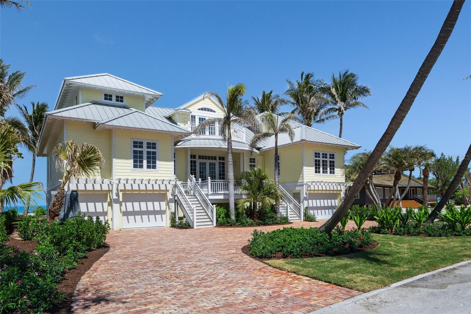 Welcome to a truly exceptional retreat, nestled perfectly between Charlotte Harbor and the pristine shores of the Gulf of Mexico. This stunning Gulf-front residence epitomizes coastal living, offering a seamless blend of traditional elegance, modern sophistication and communion with Boca Grande’s Old Florida lifestyle. The generous 1.16- acre lot which includes ownership of the adjacent eastern lagoon is situated on one of the Islands premier private roads improved with only gulf front homes and exclusive beach access.  This traditional coastal-style residence is complete with 5 bedrooms and 6.5 baths and its custom construction is a true masterpiece of design and craftsmanship. The spacious and open floorplan provides breathtaking Gulf or Harbor vistas from almost every room and all three levels of the residence are accessible by stairs or elevator which are in close proximity to both garage facilities. The gourmet kitchen is beautifully outfitted with custom wood cabinets, twin Sub-Zero refrigerators, Sub-Zero beverage drawers, Wolf cooktop, double ovens and a multitude of fine custom finishes.  The main living floor also includes a luxurious primary bedroom with separate dual baths, large custom closet and direct access to an elegant den/office. The second living level includes three generously sized guest suites, each with their own bath, as well as a second laundry room, a study, and a comfortable living room with gorgeous waterfront porches. The residence enjoys a refined aesthetic complete with beautiful hardwood floors, smooth drywall finishes, faux painting, custom built-ins and beautiful wood moldings all of which are enhanced by the properties whole house Lutron lighting system. The grounds are beautifully landscaped and   highlighted by an in-ground pool and private beach access. This stunning outdoor Oasis is perfect for serene quiet time, family gatherings and entertaining friends.  This Boca Grande gem is more than just a home; it's a lifestyle. With its prime location, stunning views, and unparalleled craftsmanship, this beachfront estate presents a singular opportunity to own a truly exceptional piece of Gulf Coast luxury.