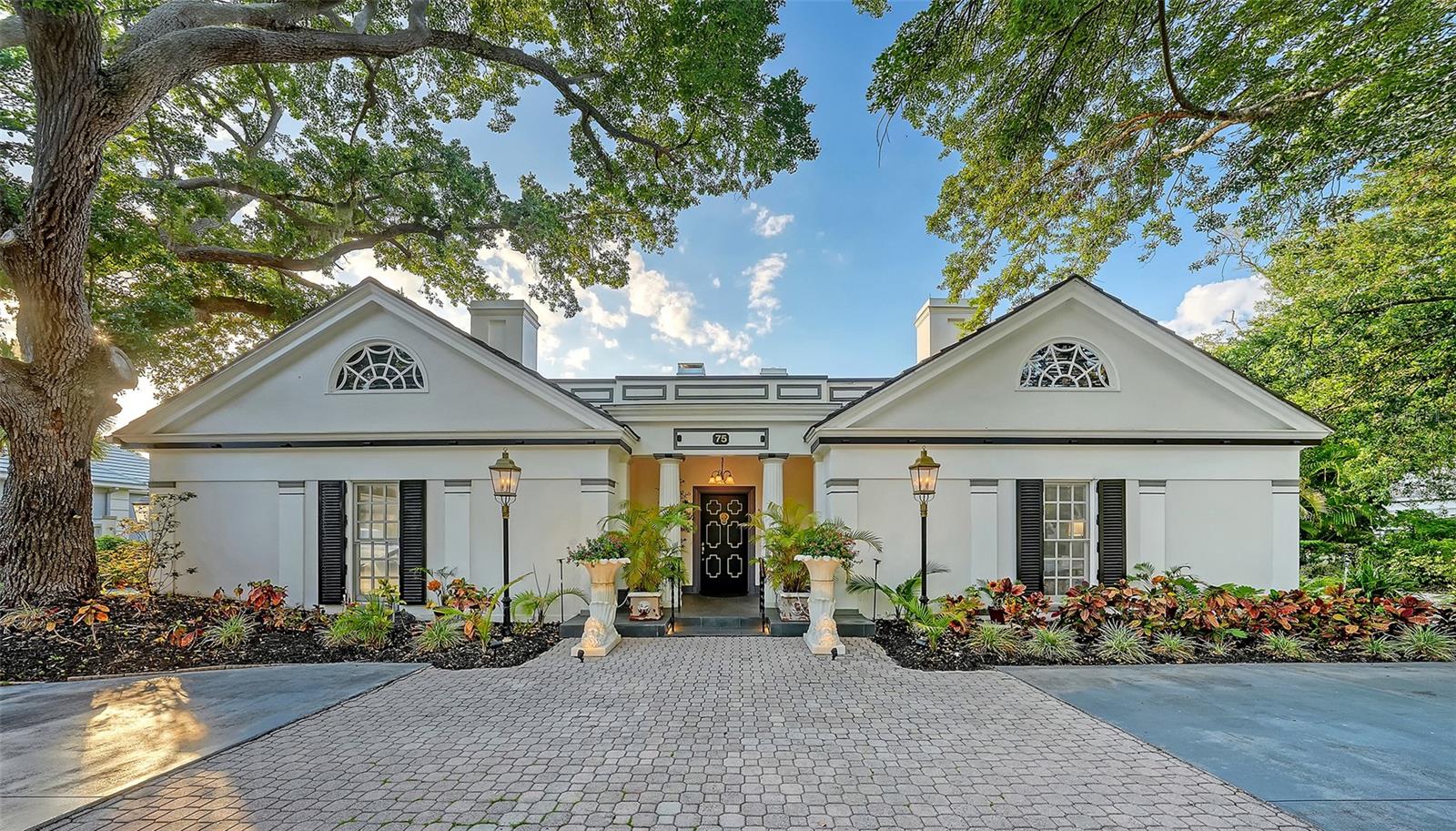 Offered at a price approaching the value of the two buildable lots alone, this architect-designed estate represents one of the most compelling opportunities currently available in The Oaks.

Nestled beneath majestic oak trees and surrounded by exceptional privacy, this architecturally significant residence was designed by and as the personal home of renowned architect Bo MacEwen. The property encompasses two buildable lots and includes a charming guest house, creating a rare and versatile estate setting.

A grand foyer measuring approximately 12 feet wide by 19 feet long welcomes guests and leads to an impressive great room featuring soaring vaulted ceilings, a gas fireplace, and a dramatic bay window with built-in seating overlooking the beautifully landscaped grounds. Architectural details abound, including 14-inch crown molding, Palladian windows, wainscoting, skylights, custom lighting, and distinctive craftsmanship throughout.

The home offers four bedrooms and four full bathrooms, thoughtfully designed to blend elegance, comfort, and timeless architectural character. Throughout the residence, quality construction and meticulous attention to detail reflect the vision of its celebrated designer.

Step outside to discover a tranquil, resort-inspired setting featuring a sparkling pool, lush landscaping, and a separate guest house ideal for visitors, extended family, or a private office. In the evening, landscape lighting transforms the grounds into a serene retreat unlike anything else in the community.

Residents of The Bayside enjoy a 24-hour guarded entrance and a private community pier perfect for kayaking, fishing, or taking in spectacular sunsets over Casey Key.

Ownership also provides access to the exceptional lifestyle of The Oaks Club, featuring two championship 18-hole golf courses, 12 Har-Tru tennis courts, four pickleball courts, the state-of-the-art WellFit Center, a Junior Olympic swimming pool, outstanding dining venues, and an active year-round social calendar.

Club membership is required, and there is currently no waiting list for either Golf or Sports/Social membership.