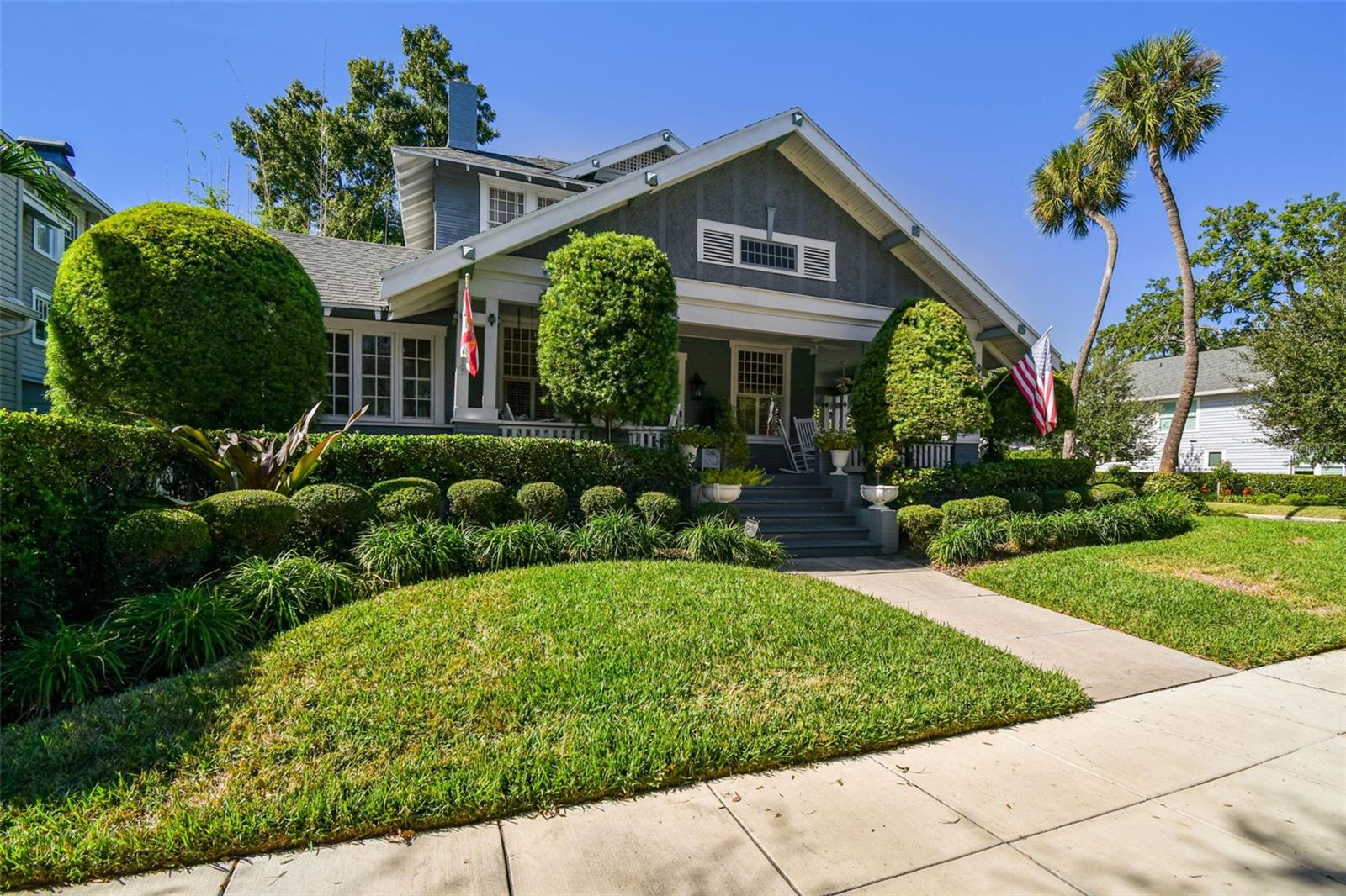 Under contract-accepting backup offers. Set on a prominent corner lot in the heart of Hyde Park, this historic home offers timeless character, thoughtful updates, and arguably some of the best views of Bayshore Boulevard and six blocks from Hyde Park Village. A sweeping wrap-around porch immediately welcomes you, anchored by a charming Dutch door that serves as a nod to the home’s rich history and sets the tone for what lies within. Step inside to find soaring 11-foot ceilings and a formal living room centered around a wood-burning fireplace with coffered ceilings and raised paneled wainscoting creating a warm and inviting first impression. Just off the living room, a sun-filled sitting room provides a peaceful retreat bathed in natural light—ideal for reading, relaxing, or enjoying morning coffee. You are welcomed through the dining room that overlooks the side patio and garden through large original windows.The home then opens beautifully into the kitchen and main living area, where an open-concept layout allows for effortless flow and everyday living. The kitchen features two islands, gas stove, bar seating, custom cabinetry, and a built in work station. An eat-in breakfast area connects seamlessly to the large living space and kitchen, making it perfect for entertaining. Two separate porches extend from both the living area and the breakfast space, offering multiple opportunities to enjoy the lush grounds and meticulously landscaped outdoors.The primary suite is conveniently located on the main level and serves as a private sanctuary. The updated en-suite bathroom includes a soaking tub, walk-in shower, and custom inset storage thoughtfully designed to fit the space. Off the primary bedroom, a sunroom offers exceptional flexibility—ideal for a home office, nursery, gym, expanded closet, or private TV or reading room. An updated half bath with a designer’s touch completes the main floor. Upstairs, the second level features four bedrooms, including two generously sized rooms with peek-a-boo water views of Bayshore Blvd. Two additional bedrooms are filled with historic charm and character, complemented by two full bathrooms that serve the upper level with ease. Adding to the property’s versatility is a detached guest house located above the one car garage, complete with a full bathroom. Perfect for visitors or a private workspace, this additional living space enhances both functionality and value. Additional features include 4 AC units (2017-2026) with all new duct work, 3 water heaters (2020-2024), structural support updated (2025), and all electrical wiring updated (2025). This exceptional Hyde Park residence seamlessly blends historic charm, thoughtful design, and modern livability—all in one of Tampa’s most iconic locations.