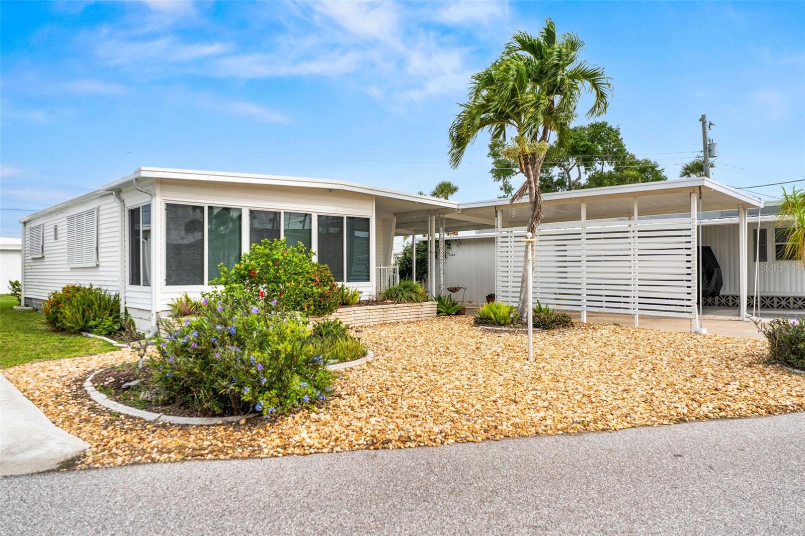 Nestled in the heart of Venice within a vibrant 55+ boating community, this beautifully landscaped residence offers the ultimate Florida resort lifestyle just a seven-minute boat ride from the Gulf of Mexico via the Intracoastal Waterway. The home has been meticulously updated with smooth insulated drywall throughout, a eight-year-old A/C, and a brand-new 2025 roof accented by stylish new Bahama shutters. Outside, the property features an incredible, ultra-durable 48-foot carport engineered to withstand 150 mph hurricane-force winds. This massive structure easily shelters three vehicles while doubling as a fantastic, shaded space for outdoor entertaining. Designed to maximize the coastal sunshine, the bright and airy floor plan flows into a covered, weather-protected 8x16 front lanai wrapped in panoramic windows, creating the perfect backdrop for dining, reading, or relaxing. As a premier destination for water enthusiasts, the community features brand-new boat docks with resident-only slip rentals. It also boasts two distinct clubhouses equipped with full kitchens, including a newly built secondary clubhouse overlooking the scenic waterway and another featuring a live performance stage. Residents here enjoy low HOA fees and flexible rental policies alongside an unparalleled lineup of amenities, allowing you to be as social as you desire with a calendar full of events to keep you entertained. This home is completely move-in ready and priced to sell, offering a rare opportunity to start enjoying the true Florida experience you have been waiting for.