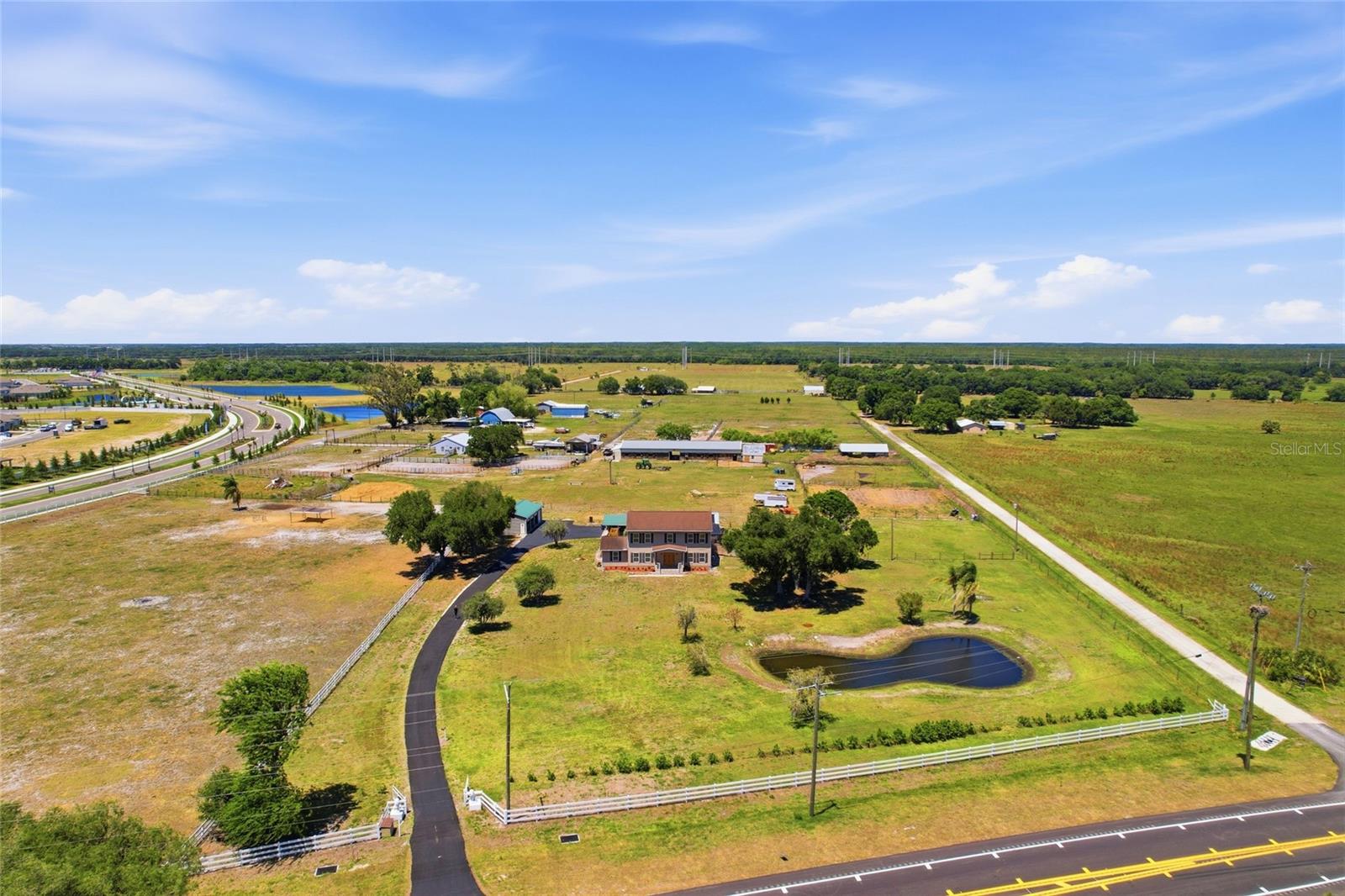 Now offered under $1M, this nearly 7-acre Parrish property offers rare flexibility with agricultural zoning, usable land, horses currently on property, and no HOA or CDD restrictions.
Private gated estate in Parrish offering room for RVs, boats, equipment, or workshop potential — opportunities like this are becoming increasingly limited in the area. Enjoy peaceful country living with the ability to live, work, and store what you need, all while remaining close to daily conveniences and commuter routes. This well-maintained home offers 3 bedrooms, 3 bathrooms, a separate office ideal for remote work or hobbies, and 2,644 square feet of living space with generously sized bedrooms, including two with en suite bathrooms ideal for guests or multigenerational living. Relax on the welcoming front porch overlooking the pond, or enjoy the screened lanai with private pool and spa, perfect for entertaining or unwinding in private surroundings. Pool resurfaced in 2020. Solar heat and pump replaced in 2019. New screening on enclosure. Separate fenced dog pen just off the lanai provides a secure space for pets. Built for both comfort and function, the property includes two oversized garages, one measuring approximately 50.3' x 24' with workshop space and attached 24' x 22' carport, and a second garage measuring approximately 40.2' x 24.4'. Covered parking for up to 10 vehicles. Enjoy the freedom to store boats, RVs, trailers, tools, hobbies, and recreational vehicles on your own property. Major improvements include roof replaced in 2019, two central AC systems with one replaced in 2019 and the other in 2024, mini split added with home addition in 2021, 80-gallon stainless steel water heater replaced in 2020, vinyl siding updated in 2018, electrical panel replaced in 2026, and water treatment system. Fully fenced agricultural-zoned property offers room for animals and flexibility to expand or add structures subject to county approval. Located in Flood Zone X. Serviced by well and septic. Properties offering this combination of acreage, privacy, functionality, and updates rarely become available in today’s market.