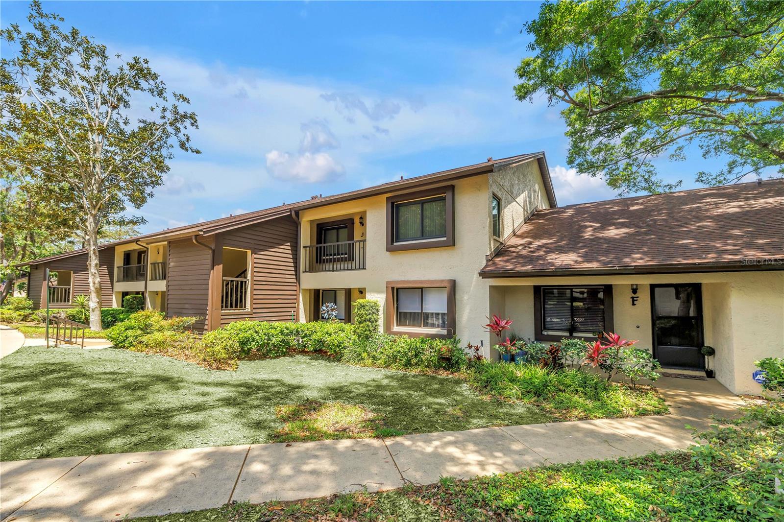 DON’T MISS THIS GORGEOUS CORNER UNIT in a park-like community - 2 bedroom, 2 bath, with your personal carport close to your front door! This home also includes a bonus room - great space for a home office or hobbies. Being an end unit, BOTH bedrooms feature a side window for extra brightness and views. Extra windows make this home light and bright! The open floor plan is easy for entertaining. The large kitchen is the home-chef’s dream with TONS of cabinetry and space for an eat-in bistro set. Master bedroom includes an en-suite bathroom and large walk-in closet. Split plan layout allows for both bedrooms to have privacy and both are generously sized. Make chores a breeze with this in-unit private laundry room with the included full sized washer and dryer. Other upgrades include: NEW Hurricane impact windows (2018), NEW Water Heater (2026), NEW Washing Machine (2026) and the same beautifully continuous tile throughout. This community is set in a park-like atmosphere, is quiet and includes a gorgeous community pool. Close to the Pinellas Trail, Downtown Dunedin, Countryside mall, shopping, restaurants and award-winning beaches including Honeymoon Island and Clearwater Beach! Magnolia Ridge offers an easy-living lifestyle with a low HOA that includes internet, cable, water, sewer, and trash. Not in a flood zone – SAVES YOU MONEY and provides peace of mind $$!!