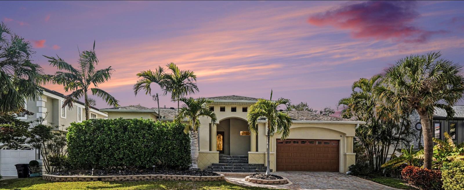 Experience the effortless coastal lifestyle in this exceptional Tierra Verde residence, located in one of Florida’s premier boating communities on the West Coast. From the moment you arrive via the pavered driveway and welcoming covered front porch, it’s clear this home was thoughtfully designed for both relaxed everyday living and memorable entertaining. The spacious kitchen is the heart of the home, featuring high-end appliances, generous counter space, and an expansive granite-topped bar that invites guests to gather before enjoying meals in the adjacent dining room. Just beyond, a dedicated 20x20 home theater delivers the ultimate movie-night or game-day experience, complete with a cozy bar area and a 92-inch projection screen. Downstairs, more than 2,300 square feet of air-conditioned bonus space offers endless possibilities for recreation and relaxation, whether hosting billiards or ping pong, unwinding in the sauna, or creating a personalized fitness or hobby area. The primary suite is a true retreat, offering a spa-inspired soaking tub and a generously sized walk-in closet. Outdoors, the property transforms into a private resort with retractable awnings, elegant travertine pavers, and manicured turf creating an ideal setting for entertaining or quiet evenings by the water. The pool features swim jets perfect for exercise or paddle training, along with a bubbler and waterfall that flow seamlessly into the six-person spa. Boaters will appreciate the newer 16,000-pound boat lift and dual wave runner lift with remotes installed in November 2021, while a whole-house propane Generac generator provides peace of mind year-round. Additional highlights include a newer roof installed September 2021, gas stove and dryer, and thoughtful upgrades throughout. Located just minutes from the nation’s top-rated beaches and the vibrant culture, dining, and waterfront lifestyle of downtown St. Petersburg, this Tierra Verde home offers the perfect blend of luxury, comfort, and island living.