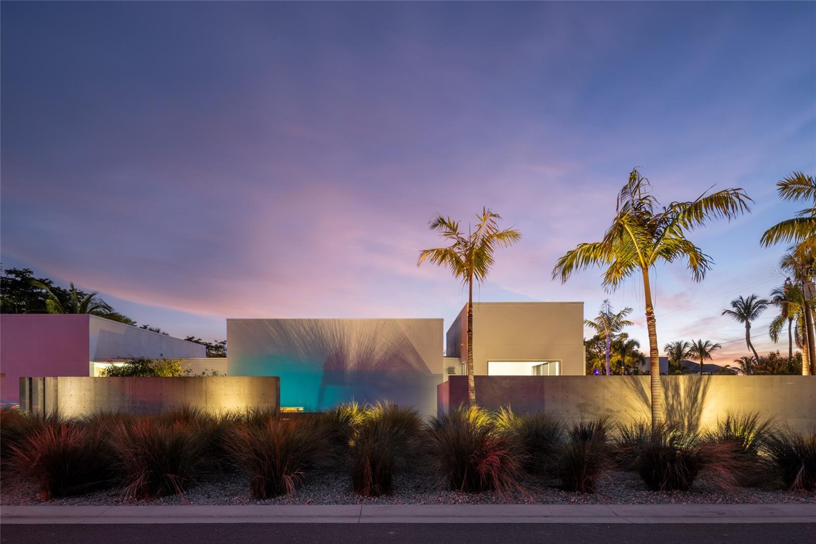 In the coveted enclave of Lido Shores, a community celebrated for its architectural innovation, this striking modern residence stands as a true work of art by renowned architect Guy Peterson. A symphony of clean lines, open volumes, and coastal serenity, the home captures the very essence of Sarasota’s modernist heritage while embodying an effortless sense of luxury and calm. Walls of glass dissolve boundaries between interior and exterior, flooding every space with natural light and blurring the line between home and horizon. In 2022, a thoughtful transformation elevated both form and function, introducing a new dining area, a versatile family room that doubles as a library, enhanced storage, and a dedicated laundry space, all executed with Peterson’s signature restraint and precision. Outdoors, the living experience unfolds across three distinct retreats, each its own expression of tranquility. A Japanese-inspired front courtyard with a water feature welcomes guests with meditative grace. At the center, a lap pool and heated spa anchor the heart of the home, surrounded by lush gardens, a Wolf outdoor grill, and generous lounge areas ideal for entertaining. A third, private garden extends from the primary suite, offering an intimate sanctuary designed for reflection and repose. Inside, refined simplicity defines every space. The open-concept plan seamlessly connects the main living area, dining room, and gourmet kitchen, outfitted with Wolf and Sub-Zero appliances, custom maple cabinetry, and white quartz surfaces that echo the home’s modern aesthetic. The primary suite, with direct access to its secluded courtyard, features a bespoke closet system and serene ambiance that completes this private retreat. Set within a community offering exclusive access to a private Gulf-front beach, this residence transcends the notion of home. It is an architectural statement, an emblem of modern Sarasota design and a rare opportunity to own a piece of its enduring legacy.