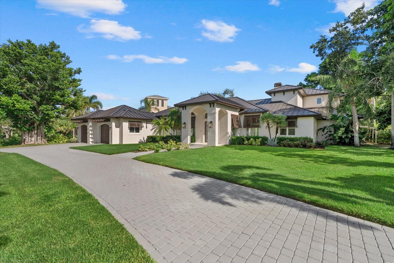 Fully renovated waterfront estate in Coral Cove, one of Sarasota’s most desirable West of Trail communities. Set on an elevated 0.59-acre corner lot directly across from the private neighborhood park and boat launch, this British West Indies-style residence offers over 5,012 square feet of updated living space, rare privacy, and the ultimate Sarasota coastal lifestyle. This 4-bedroom, 3.5-bath home has been extensively renovated and thoughtfully redesigned with modern luxury finishes throughout. Major updates include a new metal roof, impact-rated windows and doors, engineered hardwood flooring, solid core interior doors, custom organized closets, two fireplaces, and no flooding during recent hurricanes. The home offers dual primary suites, including a spacious upstairs retreat with a spa-inspired bathroom, freestanding tub, dual vanities, walk-in shower, and oversized custom closet. The chef’s kitchen is the centerpiece of the home, featuring Café Series appliances, Dolomite countertops, soft-close cabinetry, walk-in pantry, waterfall-edge peninsula seating, and a fluted designer range hood. Large living areas, tall ceilings, French doors, and expansive sliders create a bright, open layout designed for seamless indoor-outdoor living. Step outside to a private resort-style backyard with a large pool, limestone pool deck, lush lawn, mature landscaping, new dock, and floating jet ski pad. With the neighborhood boat launch just across the street, this property is ideal for boating, kayaking, paddleboarding, waterfront entertaining, and enjoying the best of Florida living. Located minutes from Siesta Key Beach, Gulf Gate, downtown Sarasota, shopping, dining, marinas, and Sarasota’s arts and culture scene, this Coral Cove waterfront home offers a rare combination of size, elevation, renovation quality, and location.