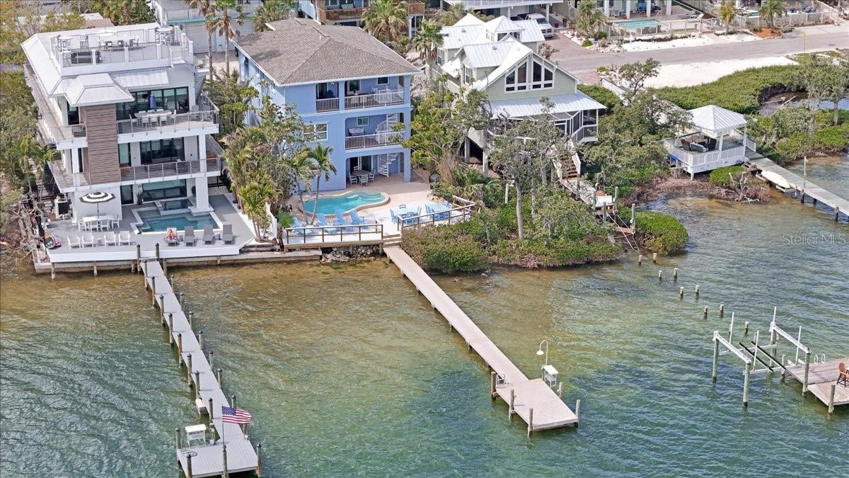 LIVE THE ISLAND DREAM - BREATHTAKING BAYFRONT HOME WITH DOCK, POOL, & WEEKLY RENTAL INCOME!
Welcome to your dream waterfront escape on Anna Maria Island, where coastal charm meets modern luxury! This elevated 3-story bayfront home is fully updated, turnkey furnished, and rental-ready, making it the perfect blend of vacation home + investment opportunity. With expansive open-water views of Sarasota Bay, this property delivers everything buyers from out of town are seeking: sun, sand, salt air - and serious ROI. 

The 4-bedroom, 5.5-bath layout is thoughtfully designed for both relaxed island living and high-end entertaining. Picture this: sipping your morning coffee on one of multiple balconies as dolphins pass by, then stepping out to your private deep-water dock (room for any size boat!) for a day on the water. Inside the home features: Light filled, coastal-inspired interiors, elevator to all floors, spacious great room and kitchen combo, primary suite with water views, bunk room, full laundry, outdoor shower, oversized 4-car garage with pool bath and entertainment space. Outside, enjoy: A newly resurfaced heated pool (2024) and deck (2023), newer roof (2019), pool heater/pump/motor (2023), HVAC (2021), ductwork and water tanks (2023), along with TREX decking and a fish cleaning station. 

This home sits just blocks from the island's famous beaches, restaurants, and shops, with direct access to boating, paddleboarding, and sunset cruising. In a top rental zone with little restrictions, it's a proven weekly rental performer - perfect for those looking to generate income when not in residence. Buyers are increasingly seeking properties that deliver experience, lifestyle, and value. This delivers all three - plus breathtaking bay views from nearly every room AND a pickleball court on your street. Don't miss your chance to own a slice of Anna Maria Island paradise that's built for peace of mind and storm resilience. Offered fully furnished and ready to go - just bring your sunscreen. *Information deemed reliable but not guaranteed.  Buyers or Buyers Agent to verify.