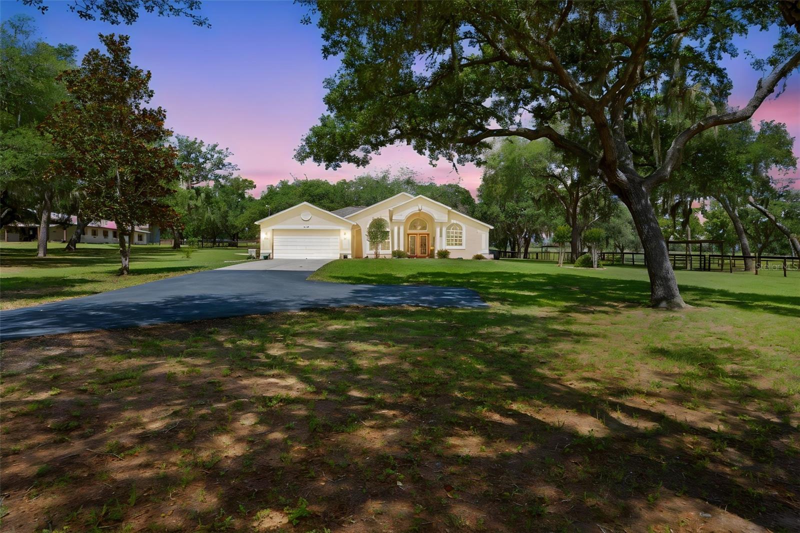 Trilby Trails Equestrian Estate | 10-Acre Custom Horse Property ~ Stunning custom built 3-bed, 2-bath, 2-car garage pool home on 10 Ag-zoned acres in the desirable Trilby Trails equestrian community. Features a 600 sq ft attached office/living quarter, 8-stall concrete block horse barn, saltwater pool, and premium upgrades throughout. The Main Residence Features Upgrades: New Roof (2024), New AC (2024), and a whole-house 24K Generac generator (2021) connected to the well. Living Area: Vaulted ceilings, great room with ledgestone walls and a gas fireplace, luxury vinyl, ceramic tile, and 9-ft triple pocket sliders leading to the pool. Chef’s Kitchen: Granite countertops, breakfast bar, stainless steel appliances, quality cabinets, a pantry, and a separate spice pantry. Master Suite: Features sliding doors to the pool, a large walk-in closet with built-ins, dual sinks, a free-standing tub, and a glass shower. Outdoor Oasis: Heated saltwater pool (resurfaced 2020) with a spa, waterfall, and custom pavers (2020), covered lanai, and an entertainer’s covered ceramic-tiled patio. Equestrian Facilities & Horse Barn: Massive 80x40 concrete block barn with 8 stalls, metal trusses, metal roof (rescrewed 2024), auto fly spray system, plus air conditioned  tack/feed and laundry rooms. Living Quarters: 600 sq ft attached office/living space with kitchen, full bath, (new 2024 AC). Gorgeous 10 lush acres, fully fenced, and cross-fenced acres with scattered oaks. 3 fully irrigated paddocks with individual water access.  New 2025 electric gate entrance, new asphalt driveways (2021), a 50-ft round pen, and two storage sheds (one with electricity).  250-ft deep well with a new 5 HP pump 2022. RV-ready with a 30-amp hookup, septic dump station, and RV carport. Trilby Trails offers miles of horseback riding trails and just a few miles away is Withlacoochee State Trail with 47 miles of biking, skating & walking trails. It is one of the longest paved trails in Florida. Don't miss Shopping downtown Dade City to experience the antique stores, boutiques, jewelry stores and many fine dining restaurants.