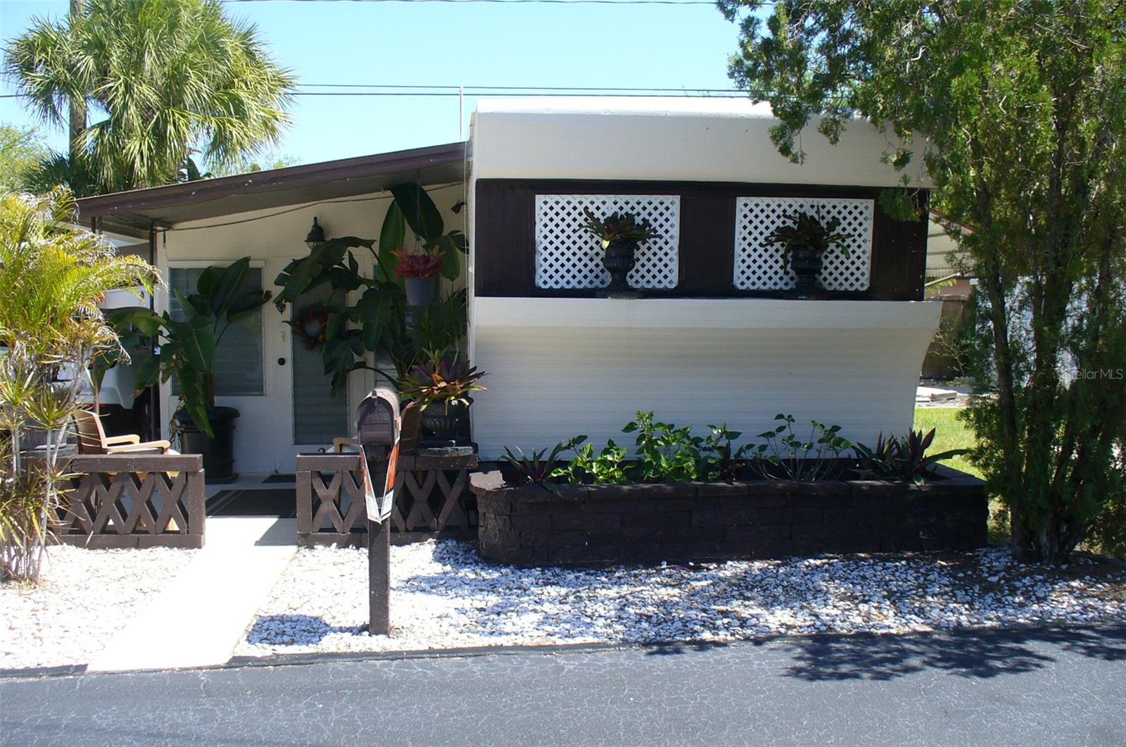 "NEW MOON" mobile home in 55+ RESIDENT OWNED park in one of the best and safest neighborhoods in St. Petersburg. Owned for 21 years by non smoking older handyman and veteran. Fully furnished = 50" Sony LED TV, surround sound system, leather furniture, zero gravity recliner, memory foam mattress, locker, office, file cabinet & jewelry chest. Huge back yard (probably the best lot in the park), no neighbors on two sides means privacy, 2 patios, 5 gardens, enclosed porch, covered carport with parking for two, wood barn style shed, newer appliances = propane stove, new propane tank & regulator, refrigerator, wall AC, combo washer/dryer, micro/convection/air fryer, bathroom vanity and toilet and water filter in kitchen sink. Mobile is 460 sq. ft. plus large porch, front half of mobile rebuilt with pressure treated 2x4's, spray foam insulation, sheet rock, wood floor, windows. Roof sealed and mobile painted in 2024, then wood shed, 2 patios, office and bathroom painted 9 months ago. Low park fees $177 includes water sewer garbage and lawn, no land lease. Cats and small dogs OK (max 2). Great to live in or as rental property (no restrictions). Across from the 133 acre Walter Fuller Park with walking trails, a pool, picnic areas, a dog park, lake, basketball / tennis / pickleball courts and several festival & sporting events. Close to Tyrone Square mall, restaurants, auto shops, Walmart, Target and 10 minutes to St. Petersburg General and VA Hospitals. Price includes share in the co-op.