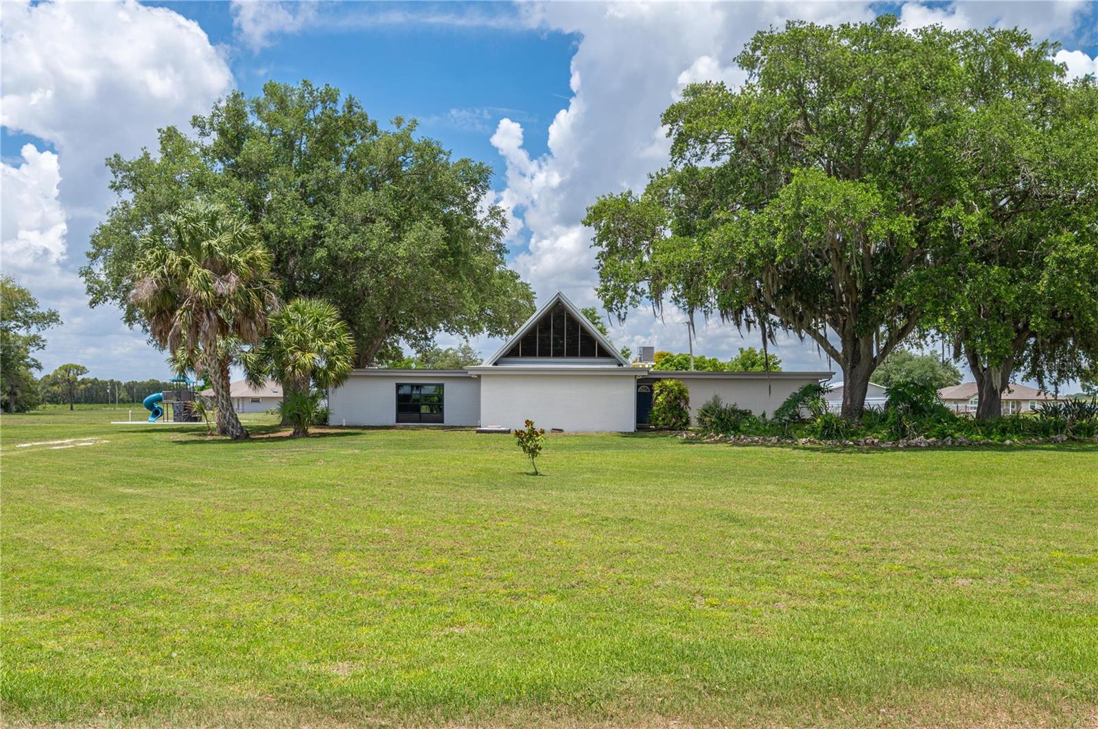 Country living at its finest! Over one acre of land and no HOA, this home is a must see! For the chef in us all, the gourmet kitchen is the heart of the home. With two large islands, there is plenty of room to prepare and to hang out. Completely remodeled with quartz counters and soft closing drawers and doors, there is storage galore! Stainless steel farmhouse sink, wine refrigerator, coffee bar area. lighted display cases and all ThinQ Series appliances from LG Studio are just a few of the things that make this kitchen so great. The A-frame design of the home allows for steep-angled ceilings and a small decorative loft in the living room. The same steep ceilings in the dining room allow for multiple windows that bring in a lot of natural light. The built in shelves, cabinets and wood-burning fireplace complete the coziness of this room. There is also a large family room with a 7x7 room that can act as more storage or a small hobby room/office. The primary bedroom has two walk-in closets and sliders that lead to the screened patio. The his and her sinks/commodes surround the sunken shower making this a unique en suite. Two more bedrooms with a Jack-n-Jill bathroom have nooks that would be perfect for a desk. One bedroom has sliders that lead to the screened porch and the other bedroom's sliders lead to the side yard. The inside laundry has even more storage space, a sink between the raised washer and dryer and a door leading outside. Added in 2019, the 23x29 screened deck has four ceiling fans and an exhaust fan for your grill making it a perfect place to hang out and enjoy the breeze. On the property is a 24x32 workshop with electric, side attached carport and water hose on the outside. It is also piped for a dust collection system that just needs the vacuum. There is also a 12x48 barn shed with electric that is separated into two sections. Well house with water filtrations system. Water heater was replaced in 2025 with smart, leak guard functions. The duct work has the iFlo Smart Automated A/C drain line cleaning system. Drain field replaced 2020. Roof replaced 2017 (metal and thermoplastic polyolefin). Playground. Security system. Irrigation system for the front and playground side of home.