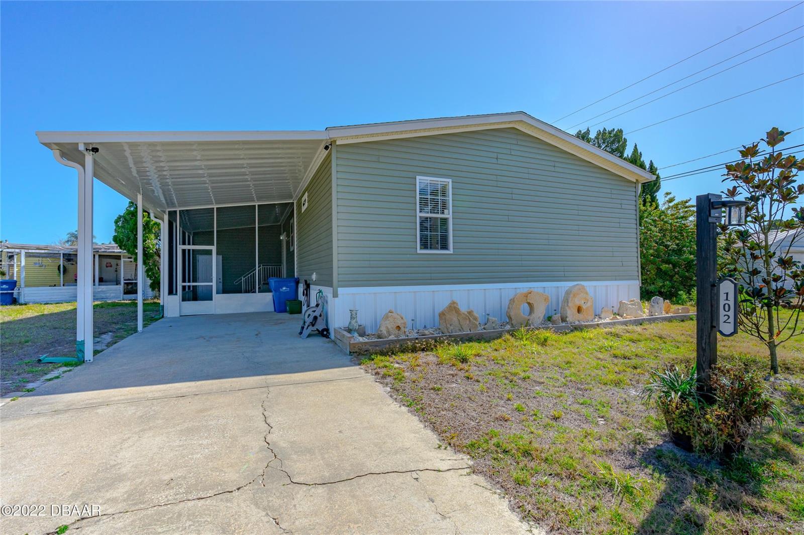 Seller offering $10,000 concessions for Buyer's closing costs or Rate Buy-Down!! Retired persons, Snowbirds, Investors....If you LOVE to FISH and BOAT, Kayak or Paddleboard, this community is perfect for you! Spot dolphins or manatees from the pier or take it to the next level with enjoying a day on the water right from your neighborhood by fishing, kayaking or boating! Start enjoying the Florida lifestyle in this 2020 built Home!! NO LOT RENT, you OWN the Land!!!  As you pull up, there is one additional parking concrete pad, and you will notice the screen enclosed patio with a privacy shade, a lovely place to sit outside and enjoy the outdoors. With 3 bedrooms, and two bathrooms you have room for guests or a family.  Upgrades include a New Metal Roof (2024) an additional parking slab (2024) Smart thermostat (2025) and new laminate flooring in two of the bedrooms (2026.) The spacious well-appointed kitchen provides an eat-in space, (table and stools included) a designated pantry, countertops for cooking space, and is open to the family room. The family room is spacious with lots of natural light. Laminate flooring runs throughout the kitchen and family room. And an extra BONUS...The sectional sofa and large wall mounted TV with entertainment center stay with the home!  The primary bedroom can handle a king size bed with nightstands and dresser (which are included) and a walk-in closet. The ensuite bathroom has both a large garden tub to relax in or a walk-in shower if you prefer. the shower has a rain shower head for added comfort.  A large window brings in natural light. The split bedroom plan has the two other bedrooms across the home, each spaciously similar in size.  The second bathroom comes with a tub and shower combo. Bidets are in both bathrooms. All but the third bedroom are new laminate flooring. The sliding doors off the family room lead to a completely fenced area for private outdoor space or for your pets to roam. The sliders, along with the family room windows provide ample natural light for the main living areas. The full-sized stackable washer and dryer are indoors to make laundry easy. The monthly recreational fee provides use to a fishing pier, boat ramp, two pools, shuffleboard and bocce, a spacious clubhouse with a large kitchen, and boat slips for an additional fee. Publix, DG Market, shopping, and restaurants are less than a 10 minute drive. Just 15 minutes from New Smyrna Beach, you can also enjoy all that beach town charm has to offer.  Call to see this property today!