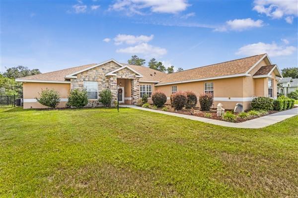Welcome to refined Florida living in this beautifully crafted custom home located in the desirable Ocala Waterway Estates. From the moment you arrive, you’ll notice the difference—this is not your typical cookie-cutter property. With timeless curb appeal, manicured landscaping, and a grand presence, this home offers character, space, and quality that new construction simply can’t replicate. Offering approximately 3,366 square feet of thoughtfully designed living space, this residence features 4 bedrooms and 4 full bathrooms, providing flexibility for a variety of living arrangements, guests, or multi-generational use. Step through the stately double-door entry into a light-filled, open floor plan with soaring ceilings and elegant finishes. The spacious great room is the heart of the home, complete with a gas fireplace and expansive views of the private screened-in pool and spa—perfect for entertaining or relaxing evenings. The chef’s kitchen is designed for both function and style, featuring custom cabinetry, stainless steel appliances, a large breakfast bar, and seamless flow into the breakfast nook and living area. The primary suite offers a true retreat with a tray ceiling, propane fireplace, and a spa-inspired bathroom featuring dual vanities, a jetted soaking tub, separate walk-in shower, and a generous walk-in closet. Three additional bedrooms and three full bathrooms provide ample space and privacy throughout the home. This property is packed with features rarely found in newer homes, including dual A/C units for zoned climate control, a newer roof (approximately 3 years old), extensive interior and exterior storage, a detached 14x21 workshop with power and air—ideal for hobbies, projects, or creative space, a 45x12 reinforced RV pad with dual 50-amp hookups, and a 3-car garage. The backyard extends beyond the existing fence line, offering additional usable space, along with underground drainage for added functionality. Conveniently located near schools, shopping, dining, I-75, and the Florida Greenway, this home offers both accessibility and privacy without the restrictions of an HOA. If you’ve been searching for a home with space, character, and true versatility, this is a rare opportunity to own something that stands apart from the rest.
