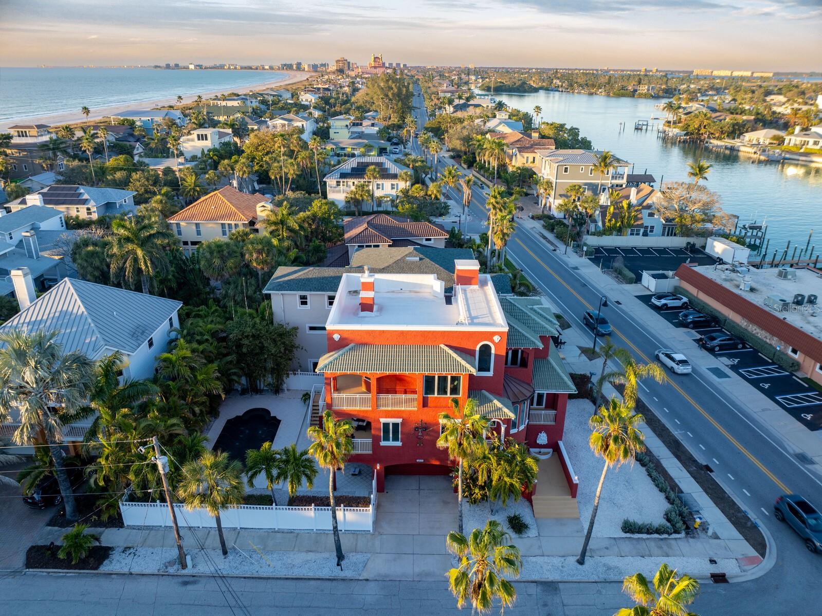 Enter the enchanting Spanish-influenced ‘Tarifa’ Residence, just a 90-second walk away from the world-famous Pass-a-Grille/St Pete Beach and the iconic Don Cesar. This extraordinary custom-built home, crafted in 2000, seamlessly fuses classic design with modern elegance, creating an unparalleled gem in the coveted Pass-a-Grille locale. Admire the allure of arched entryways, a grand stairway, private heated pool and the convenience of an elevator, raising this property to a truly exceptional status. Inside, you’ll find the timeless beauty of the open concept Chef’s kitchen, featuring a Thermador natural gas cooktop, Subzero refrigerator, pot filler, warming drawer, double sink and prep sink, both with disposals and an expansive over-sized island with granite breakfast bar. Solid wood cabinetry, backlit shelves to display your treasures, sliding drawers which provides ample storage space complimenting the overall design. The adjacent dining area, graced with gorgeous tray ceilings and French doors, welcomes natural sunlight, seamlessly connecting the indoors with the outdoors.
The stunning great room, boasting a dual-sided gas fireplace, creates an inviting atmosphere for cozy evenings on the balcony overlooking the private heated, saltwater pool and patio. The upper level includes oak flooring throughout and a magnificent primary suite with a bonus den area, a second dual-sided wood-burning fireplace, and a wrap-around balcony, offering ample space for enjoying fresh air with your morning coffee. The primary bath ensuite showcases Saltillo tile, a luxurious soaking tub, and a separate shower with dual shower heads, a new glass enclosure, and double sinks. Additional features on the upper level include a spacious guest bedroom with beautiful views of the Intracoastal Waterway from a private balcony and an ensuite bath. The lower-level guest bedroom offers a private balcony with even more Intracoastal views, a finely crafted built-in shelf system, and ensuite bath. The rooftop provides a perfect vantage point to soak up spectacular sunsets and views of the Gulf of Mexico and Intracoastal waterway. This residence offers not only beach and Intracoastal  proximity but also a luxurious pool oasis for your relaxation. After your delightful beach day, indulge in a refreshing swim or unwind in your private pebble tech heated pool – the perfect retreat in the comfort of your own backyard. Embrace the ease of strolling to Pass-a-Grille Beach, access to public, lighted pickle ball, tennis and basketball courts, as well as nearby historic downtown Pass-a-Grille. Immerse yourself in the charm of this magnificent home by taking a virtual tour.  Seize the opportunity to make this exceptional property your own, where every day feels like a vacation.