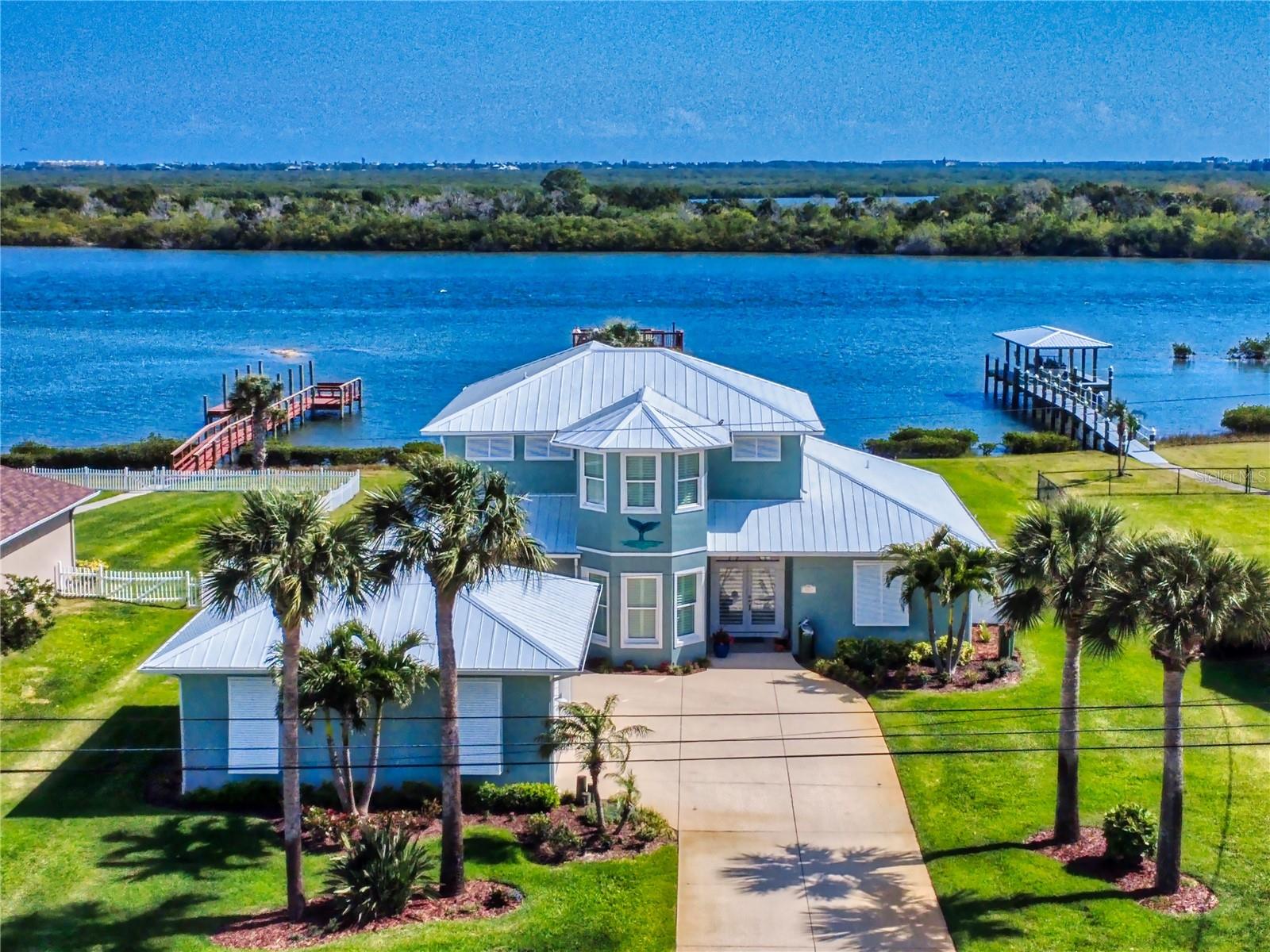 Direct Intracoastal contemporary 3-bedroom, 2-bathroom home with private dock, covered boat lift, and located on a 98 front ft X 250 ft deep lot.  This home has been meticulously renovated to offer unparalleled luxury and comfort along the  Main Channel of the Intracoastal Waterway. From the moment you enter, you're greeted by direct water views that seamlessly blend indoor elegance with outdoor serenity.
 The home  features a spacious living area with a cozy fireplace, perfect for intimate evenings, and flows effortlessly into the dining and kitchen spaces, all framed by expansive water vistas. The Culinary enthusiasts will appreciate the modern kitchen equipped with high-end appliances, Cambria counters, and stylish wood cabinetry, making both everyday cooking and entertaining friends and family a delight.
The Primary Suite with a sitting area, office and large bedroom; a perfect  private oasis that allows you to wake up to breathtaking sunrise views, complete with a private balcony overlooking the water—a tranquil spot for morning coffee or evening relaxation. There is a versatile office/personal space adjacent to the Primary Bedroom, ideal for remote work or a quiet retreat.  The beautifully tiled Primary Bathroom features a large glass enclose shower and a classic stand alone tub.

Outdoor Entertaining is easy in your screen-enclosed porch that provides an ideal setting for alfresco dining, while the sprawling lawn leads to your private dock and two-story boathouse, featuring a 6,500-pound lift—perfect for boating  and fishing enthusiasts. 
Additional Amenities include  an oversized two-car garage with an attached additional carport, professional evening ambient lighting 
 and a safe room on the first floor. 
 Experience the dynamic wildlife and the ever-changing beauty of the river  and skies, right from your backyard. This home offers  both seclusion and convenience nestled close to shopping, the vibrant Downtown Canal Street, and a golf cart ride to NSB,  our pristine beaches. Short drive to I-95 and the Sanford & Daytona Airports. Come enjoy this homes lifestyle, it's quality and pristine maintained detail, it is move-in ready, it's poised to provide its next owner with years of joy and tranquility along the water's edge on the Main Channel of the Intracoastal Waterway!