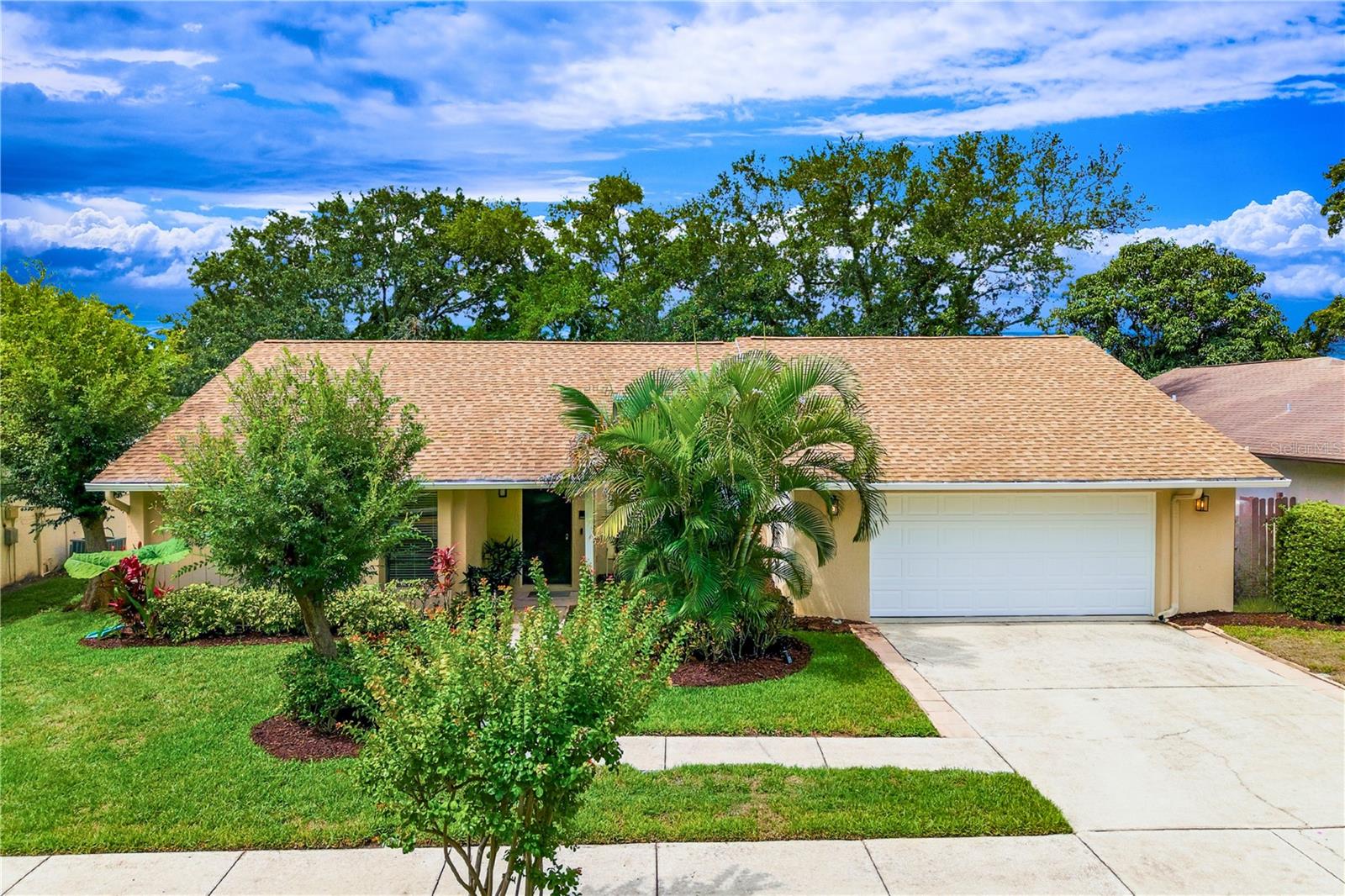 Virtually Staged. Welcome to this exceptional Palm Harbor residence, where location, comfort, and outstanding curb appeal come together seamlessly. Meticulously maintained by its owner, this beautiful home is located in the highly desirable Arbor Glen community and sits on an expansive HALF ACRE LOT. With volunteer basis HOA, a FLOOD ZONE X designation, and an impressive elevation of 41 feet, this property offers peace of mind and the perfect balance of convenience and relaxed Florida living.

From the moment you arrive, you'll be impressed by the lush landscaping, well-maintained exterior, newer garage door opener, and inviting curb appeal that set this home apart.

Step inside to discover a spacious and thoughtfully designed floor plan. The living and dining areas are bright and welcoming, featuring sliding glass doors that open to the patio and create a seamless indoor-outdoor flow. The kitchen offers abundant counter space, stainless steel appliances, and a brand-new slim microwave, making meal preparation both easy and enjoyable. Overlooking the family room, the kitchen remains the heart of the home, while additional sliding glass doors provide convenient access to the outdoor living area.

The primary suite serves as a private retreat, complete with a walk-in closet, en-suite bathroom, and direct access to the screened lanai through sliding glass doors. The second bedroom also features a walk-in closet and convenient access to the hallway bathroom. Remarkably, EVERY bedroom includes a WALK IN CLOSET,  providing exceptional storage throughout the home. Wide hallways enhance accessibility and convenience, while continuous tile flooring throughout the residence creates a clean, elegant, and cohesive look.

Recent updates add significant value and peace of mind, including a ROOF replacement in 2012, FRENCH DRAIN system and GUTTERS installed in 2012, HVAC compressor upgrade in October 2024, water heater replacement in 2025, and a new SPRINKLER system in 2025.

The outdoor living space is designed for both relaxation and entertaining. The screened patio features attractive slate flooring, three ceiling fans, and tranquil views of the surrounding landscape. Mature trees and lush greenery create a private, peaceful setting that enhances the beauty and enjoyment of the property year-round.

Ideally located, this home offers easy access to many of Palm Harbor's most sought-after amenities. Enjoy walking or biking to Palm Harbor Middle School, Palm Harbor University High School, and Ozona Elementary School. You'll also appreciate the close proximity to the Dunedin Causeway, Pinellas Trail, Publix, Aldi, local marinas, shopping, dining, Tampa International Airport, Clearwater-St. Pete Airport, and much more.

Don't miss this rare opportunity to own a beautifully maintained home in one of Palm Harbor's most desirable locations. Schedule your private showing today and experience the very best of Florida living.